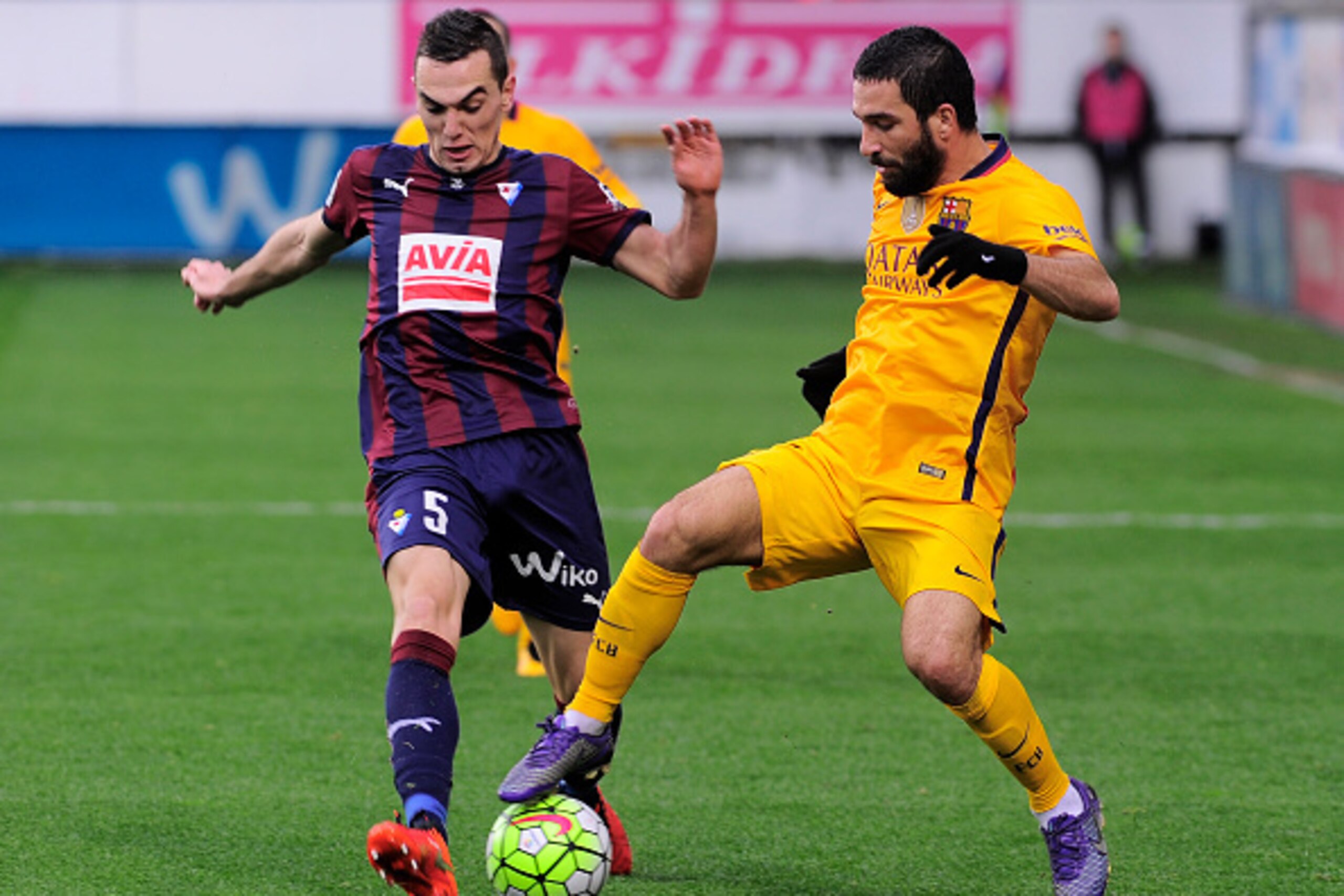 Eibar's midfielder Gonzalo Escalante (L) vies with Barcelona's Turkish midfielder Arda Turan during the Spanish league football match SD Eibar vs FC Barcelona at the Ipurua stadium in Eibar on March 6, 2016. / AFP / ANDER GILLENEA        (Photo credit sho