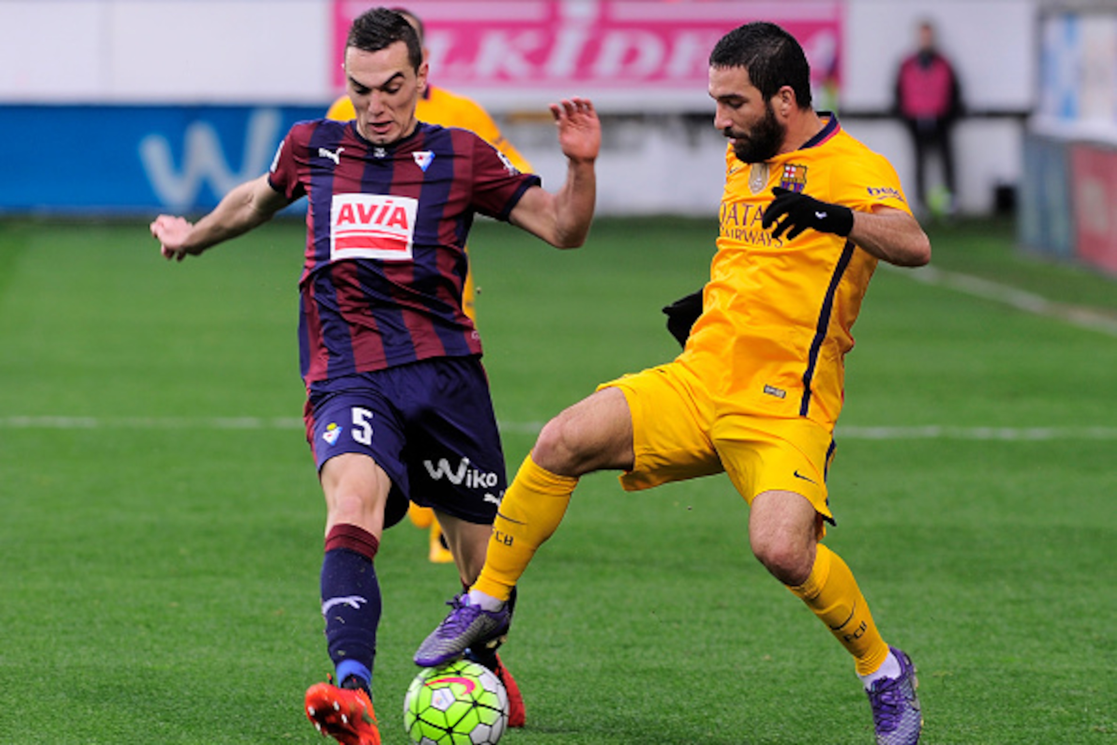 Eibar's midfielder Gonzalo Escalante (L) vies with Barcelona's Turkish midfielder Arda Turan during the Spanish league football match SD Eibar vs FC Barcelona at the Ipurua stadium in Eibar on March 6, 2016. / AFP / ANDER GILLENEA        (Photo credit sho