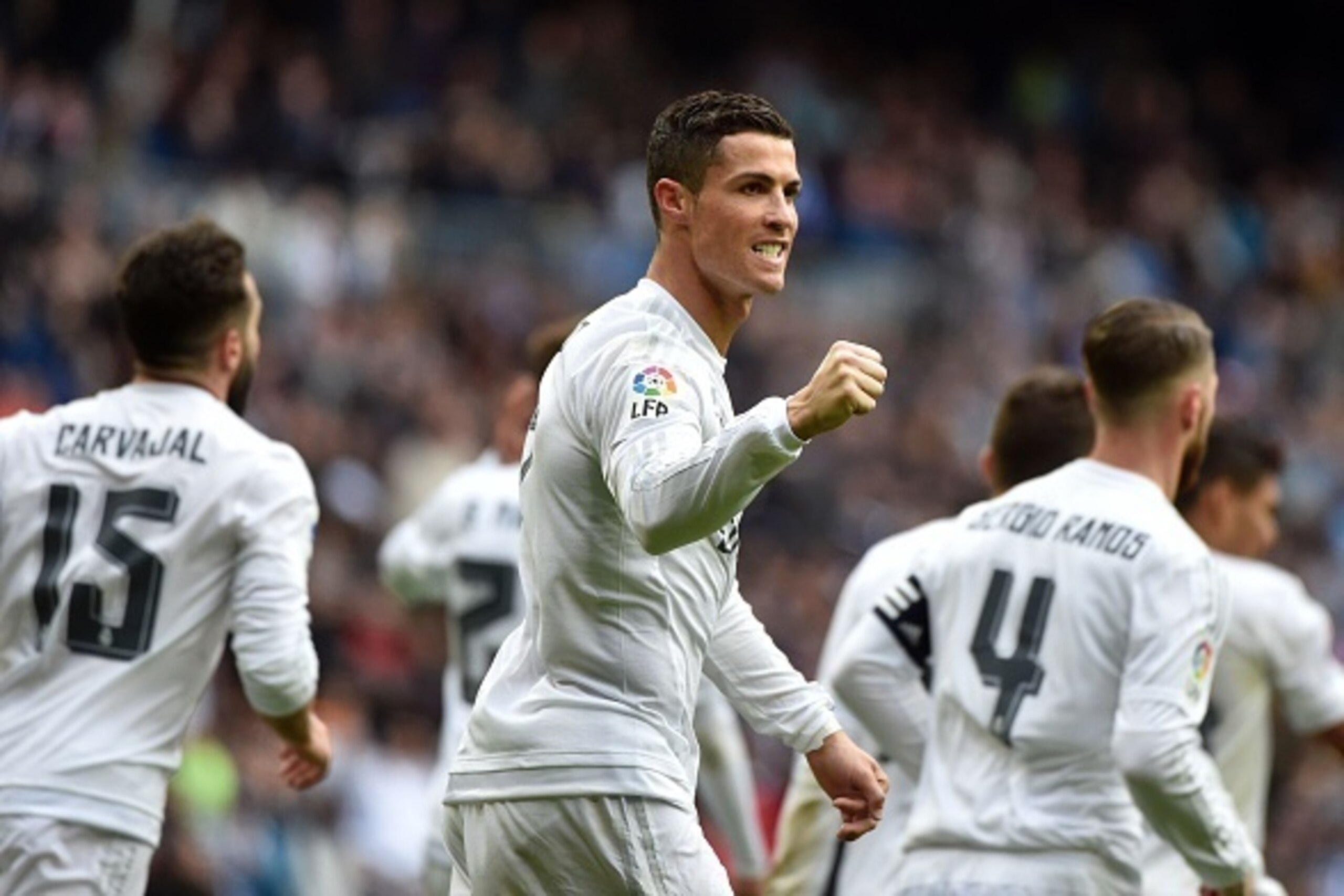 Real Madrid's Portuguese forward Cristiano Ronaldo (C) celebrates after making it a hat trick by scoring his third goal during the Spanish league football match Real Madrid CF vs RC Celta de Vigo at the Santiago Bernabeu stadium in Madrid on March 5, 2016