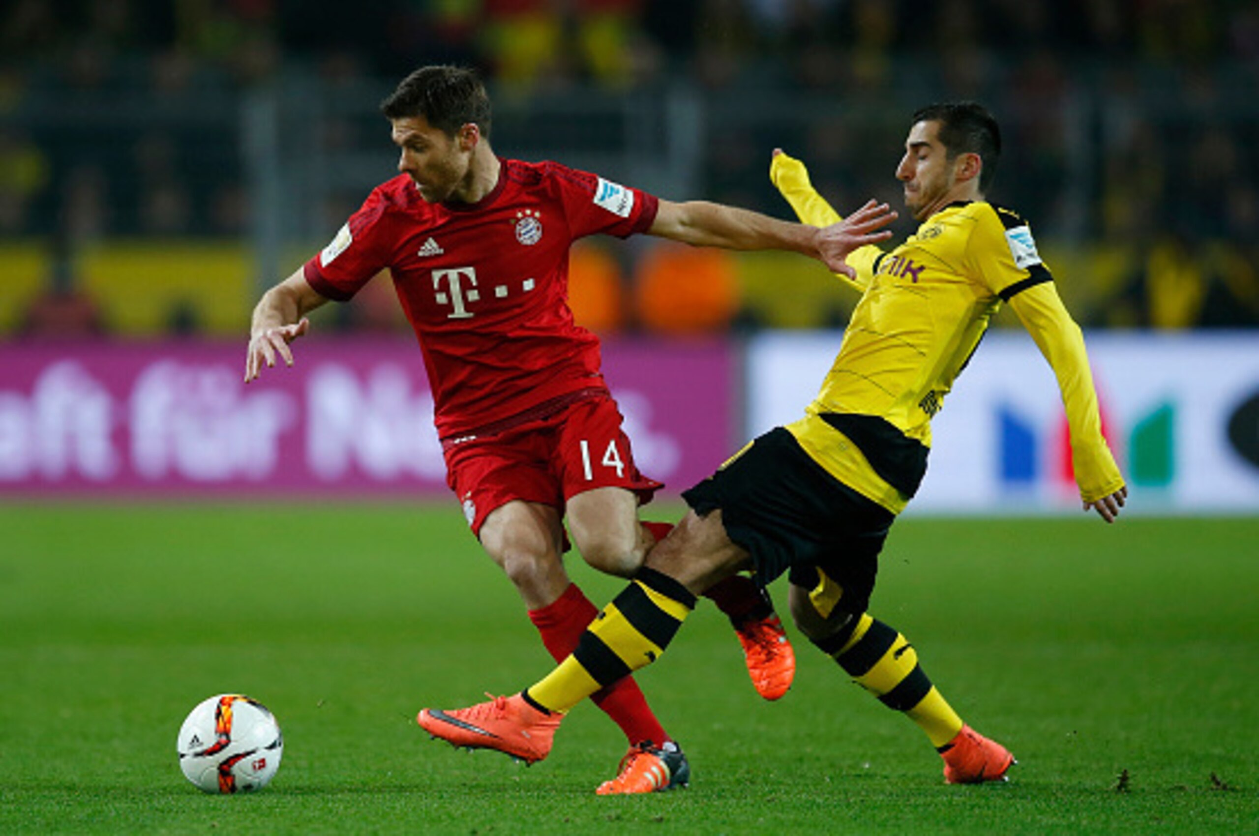 DORTMUND, GERMANY - MARCH 05:  Henrikh Mkhitaryan (R) of Borussia Dortmund challenges Xabi Alonso of Bayern Munich during the Bundesliga match between Borussia Dortmund and FC Bayern Muenchen at Signal Iduna Park on March 5, 2016 in Dortmund, Germany.bs  