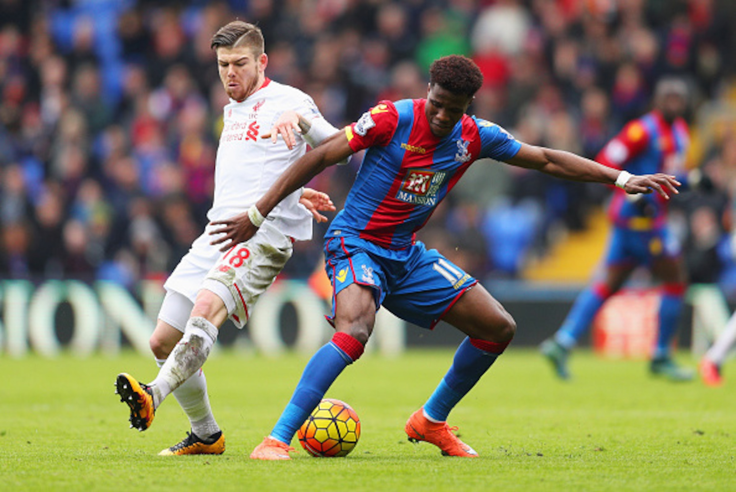 LONDON, ENGLAND - MARCH 06:  Wilfried Zaha of Crystal Palace holds off Alberto Moreno of Liverpool during the Barclays Premier League match between Crystal Palace and Liverpool at Selhurst Park on March 6, 2016 in London, England.  (Photo by Paul Gilham/G