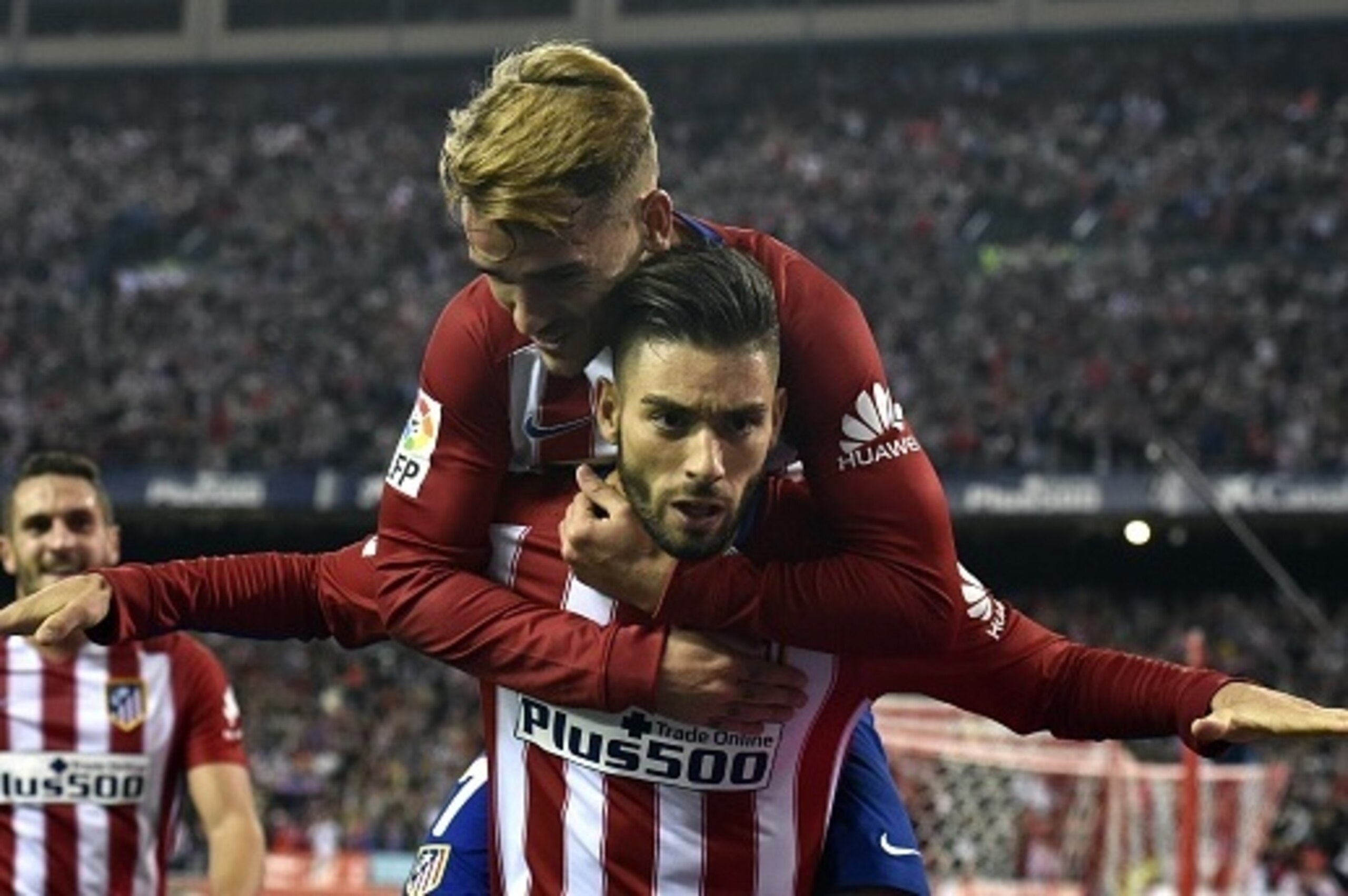 Atletico Madrid's Belgian midfielder Yannick Ferreira Carrasco (bottom) celebrates a goal with Atletico Madrid's French forward Antoine Griezmann during the Spanish league football match Club Atletico de Madrid vs Valencia CF at the Vicente Calderon stadi