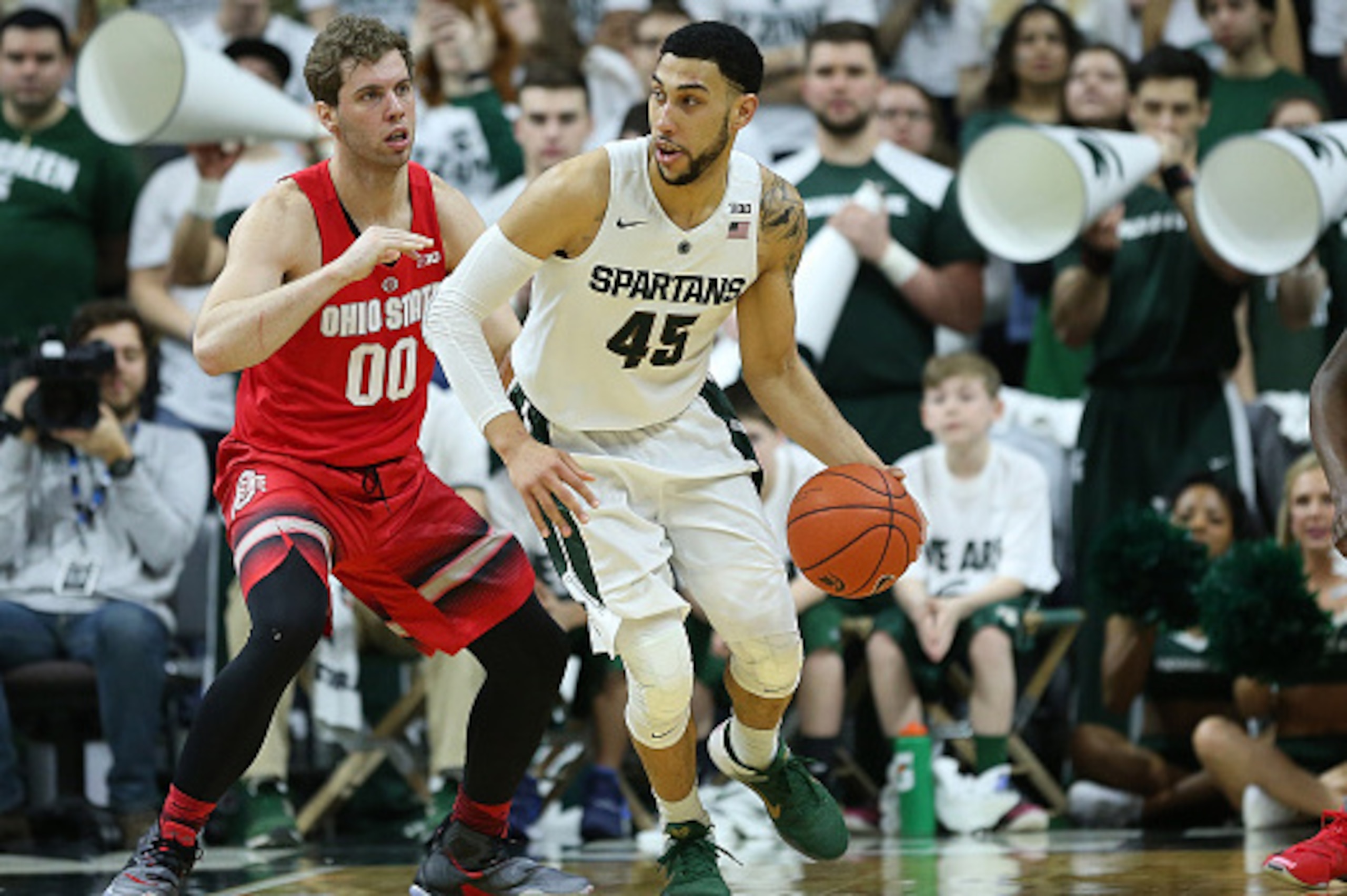 EAST LANSING MI - MARCH 5: Denzel Valentine #45 of the Michigan State Spartans dribbles the ball around Mickey Mitchell #00 of the Ohio State Buckeyes during the first half of the game on March 5, 2016 at the Breslin Center in East Lansing, Michigan. The 