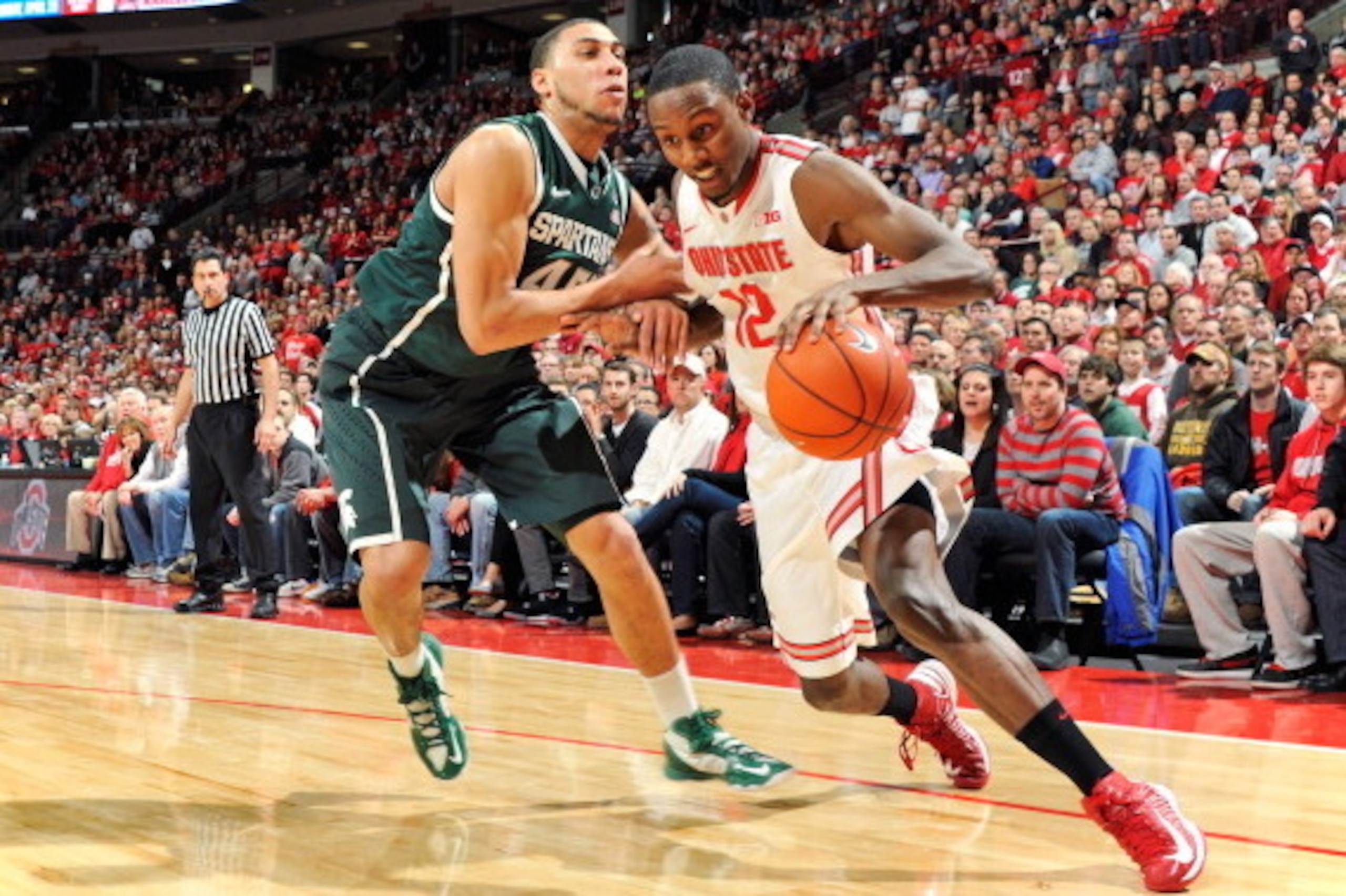 COLUMBUS, OH - FEBRUARY 24:  Denzel Valentine #45 of the Michigan State Spartans fouls Sam Thompson #12 of the Ohio State Buckeyes along the baseline in the second half on February 24, 2013 at Value City Arena in Columbus, Ohio. Ohio State defeated Michig