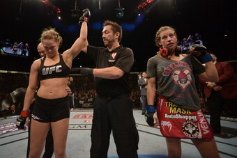 LAS VEGAS, NV - DECEMBER 28:  Ronda Rousey (left) reacts to her victory over Miesha Tate (right) in their UFC women's bantamweight championship bout during the UFC 168 event at the MGM Grand Garden Arena on December 28, 2013 in Las Vegas, Nevada. (Photo b
