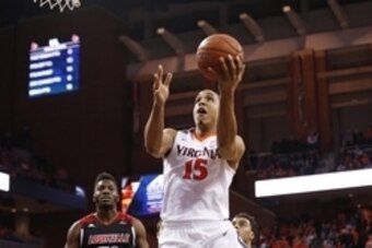 Mar 5, 2016; Charlottesville, VA, USA; Virginia Cavaliers guard Malcolm Brogdon (15) shoots the ball as Louisville Cardinals center Chinanu Onuaku (32) looks on in the second half at John Paul Jones Arena. The Cavaliers won 68-46. Mandatory Credit: Geoff 