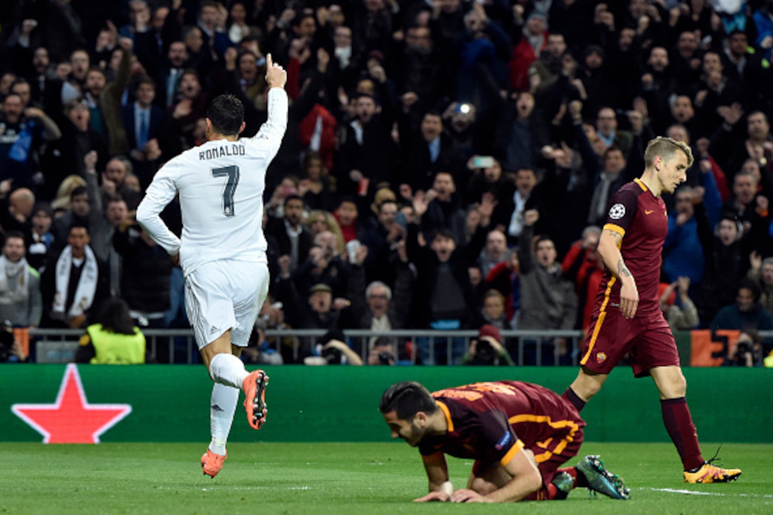 Real Madrid's Portuguese forward Cristiano Ronaldo (L) celebrate after scoringduring the UEFA Champions League round of 16, second leg football match Real Madrid FC vs AS Roma at the Santiago Bernabeu stadium in Madrid on March 8, 2016. / AFP / GERARD JUL