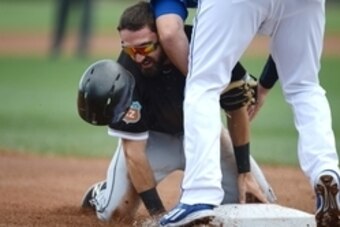 Mar 5, 2016; Surprise, AZ, USA; Chicago White Sox center fielder Adam Eaton (1) is tagged out by Kansas City Royals third baseman Mike Moustakas (8) during a steal attempt in the first inning at Surprise Stadium. Mandatory Credit: Joe Camporeale-USA TODAY