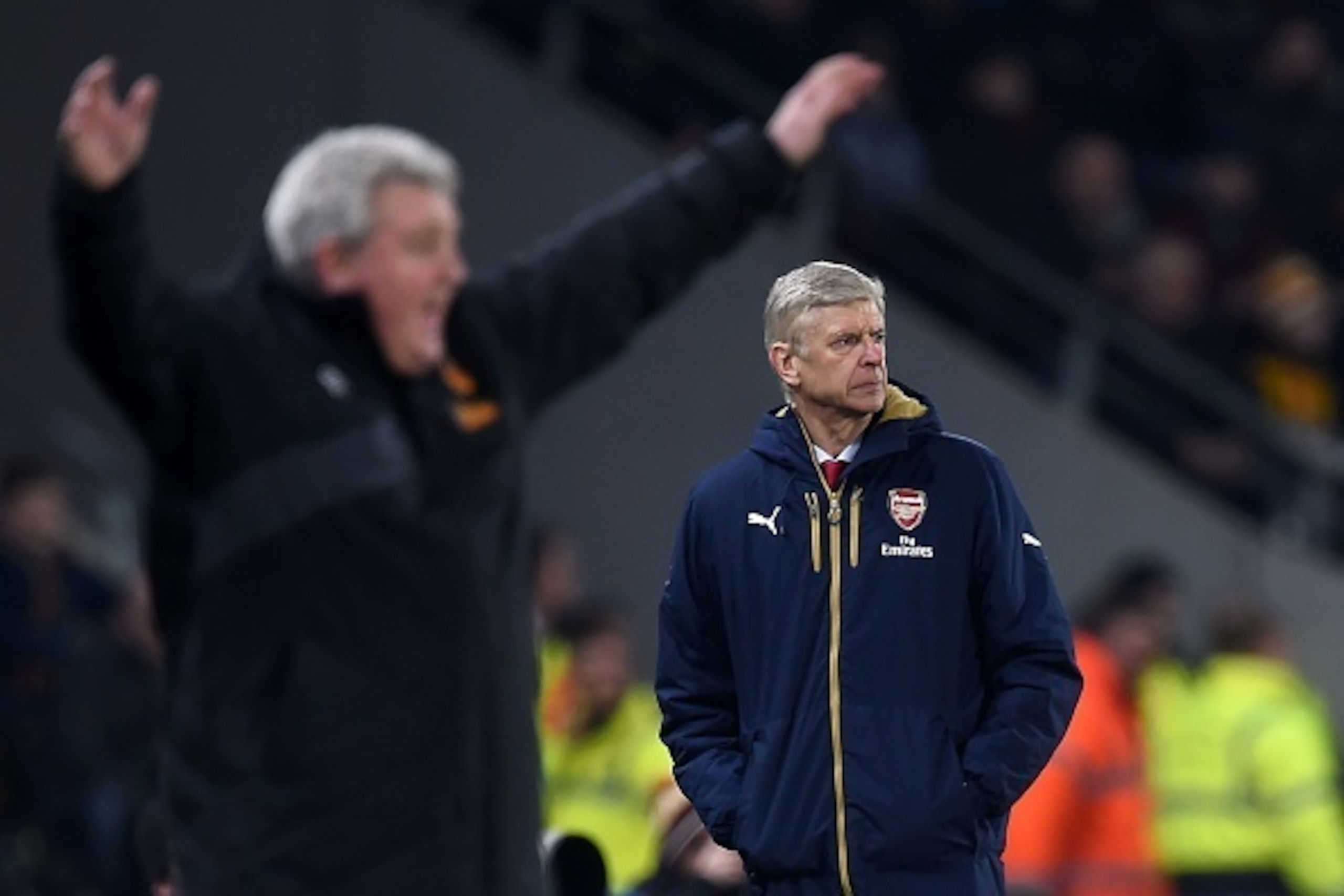 Arsenal's French manager Arsene Wenger (R) looks on as Hull City's English manager Steve Bruce reacts during a break in play during the English FA cup fifth round replay football match between Hull City and Arsenal at the KC Stadium in Kingston upon Hull 