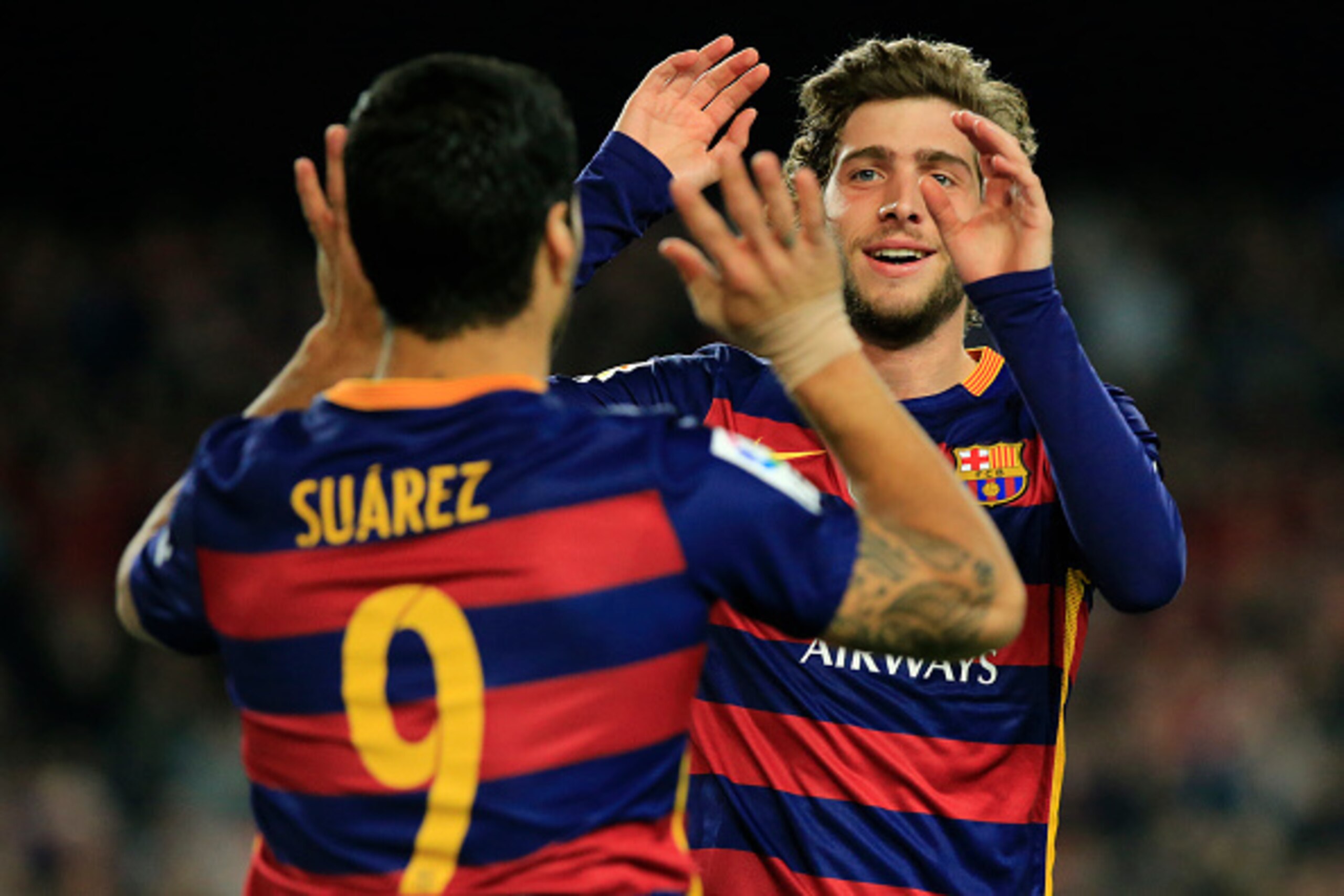 Barcelona's Uruguayan forward Luis Suarez (L) celebrates with Barcelona's midfielder Sergi Roberto after scoring during the Spanish league football match FC Barcelona vs Real Betis Balompie at the Camp Nou stadium in Barcelona on December 30, 2015.   AFP 