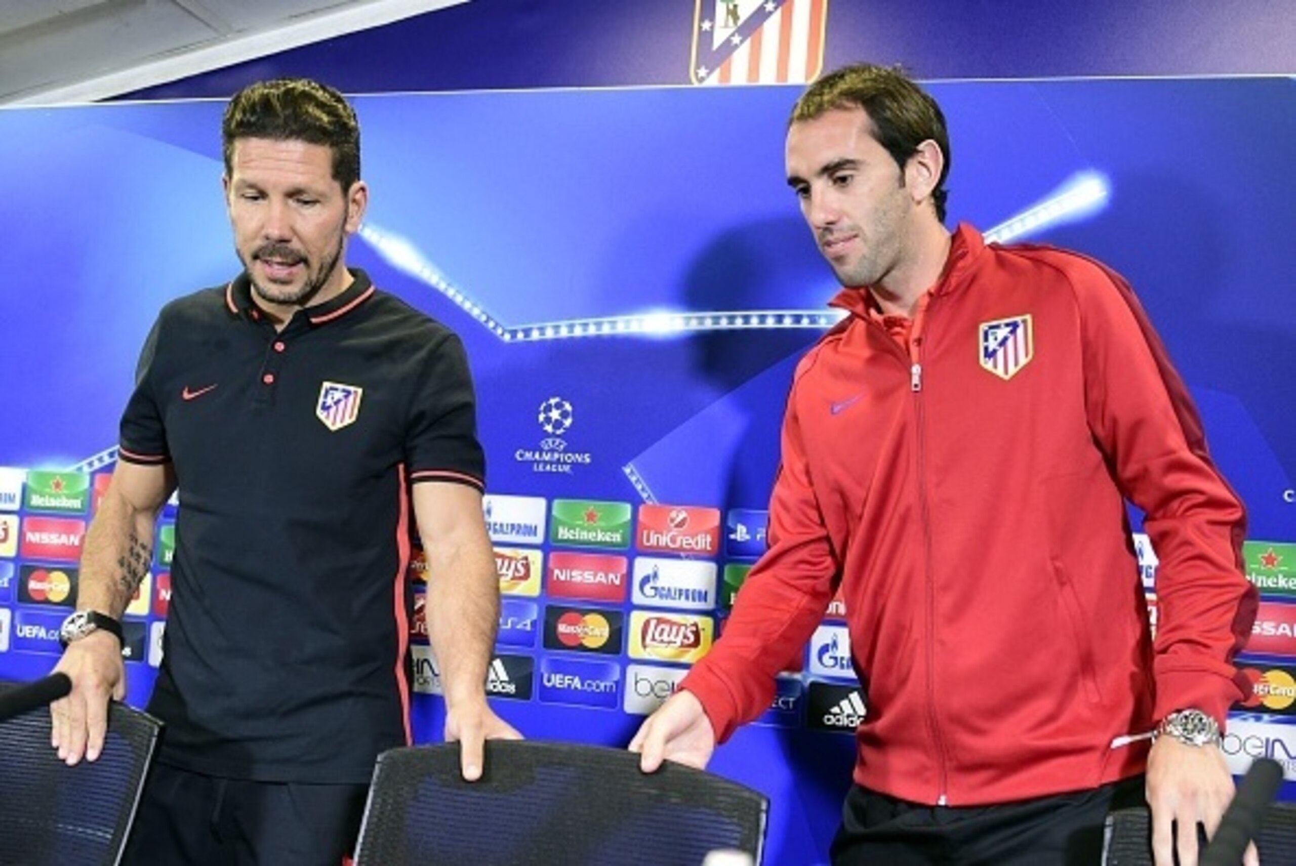 Atletico Madrid's Argentinian coach Diego Simeone (L) and Atletico Madrid's Uruguayan defender Diego Godin arrive to give a press conference at Vicente Calderon stadium in Madrid on September 29, 2015 on the eve of their UEFA Champions League football mat