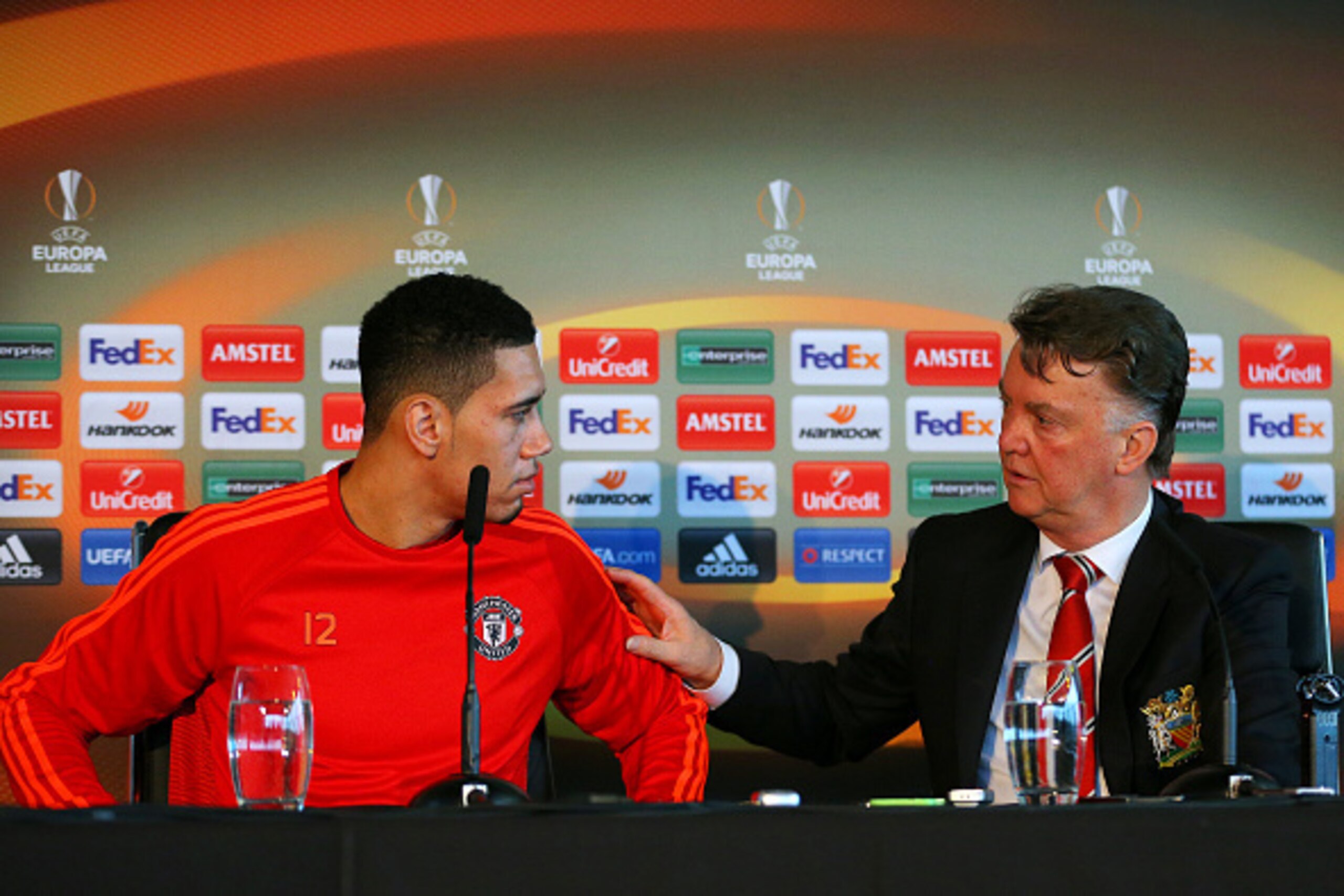 MANCHESTER, ENGLAND - MARCH 09:  Chris Smalling of Manchester United speaks with Louis van Gaal, manager of Manchester United at a press conference ahead of the UEFA Europa League round of 16 first leg match between Liverpool and Manchester United at Aon 