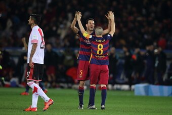 YOKOHAMA, JAPAN - DECEMBER 20: A dejected Luis Gonzalez of River Plate as Sergio Busquets and Andres Iniesta of FC Barcelona celebrate victory during the FIFA Club World Cup Final Match between FC Barcelona and River Plate at International Stadium Yokoham