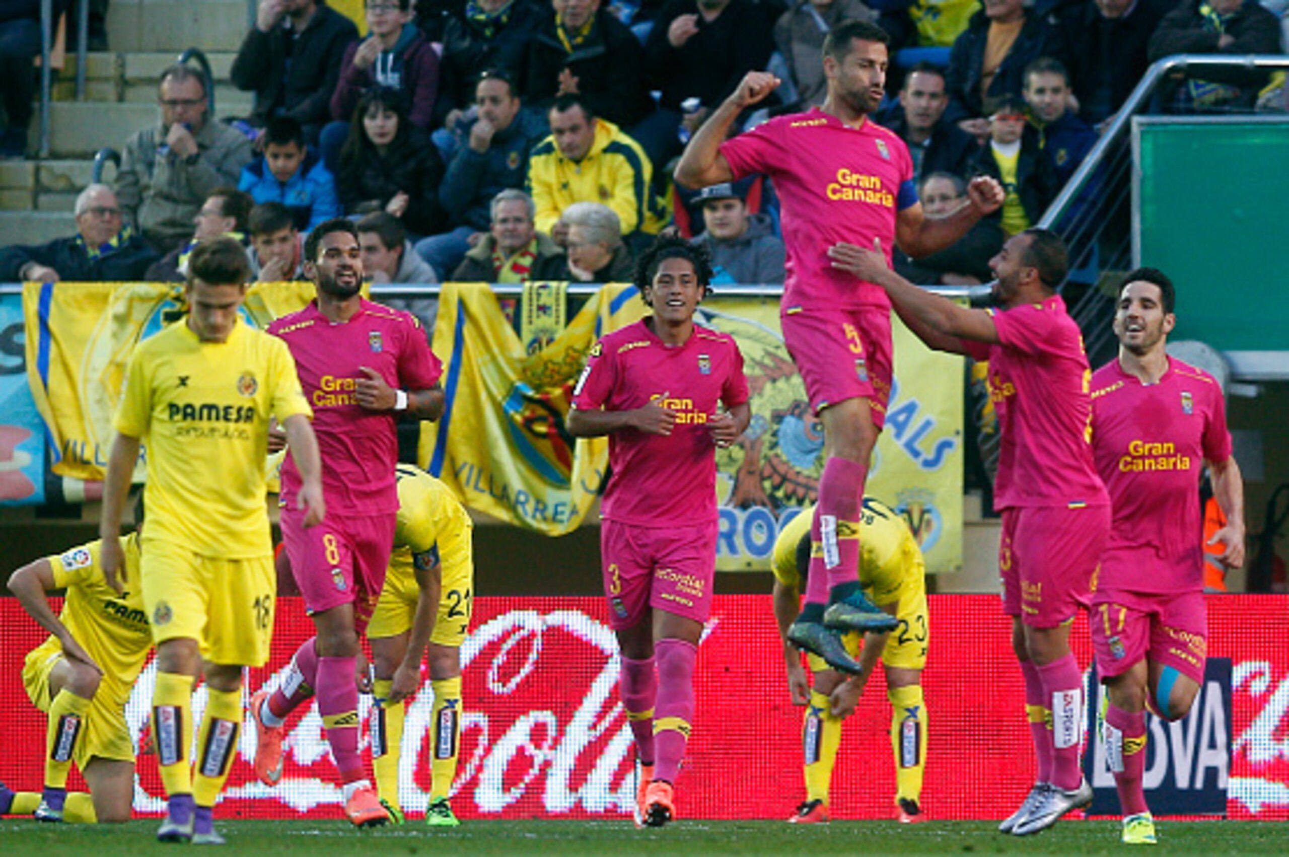 Las Palmas' defender David Garcia (top) celebrates a goal with teammates during the Spanish league football match Villarreal CF vs las UD Las Palmas at El Madrigal stadium in Vila-real on March 5, 2016. / AFP / JOSE JORDAN        (Photo credit should read