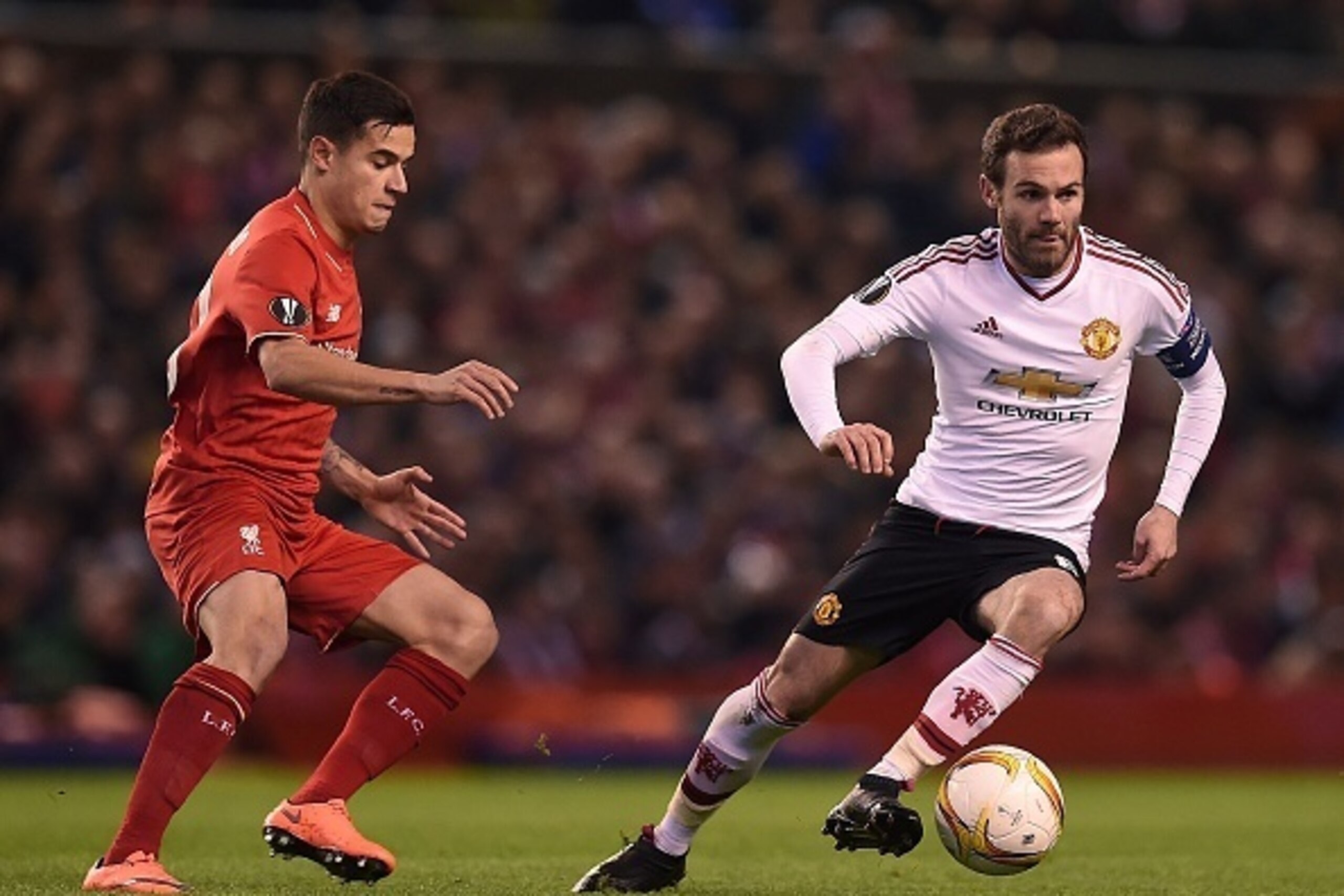 Liverpool's Brazilian midfielder Philippe Coutinho (L) vies Manchester United's Spanish midfielder Juan Mata with during the UEFA Europa League round of 16, first leg football match between Liverpool and Manchester United at Anfield in Liverpool, northwes