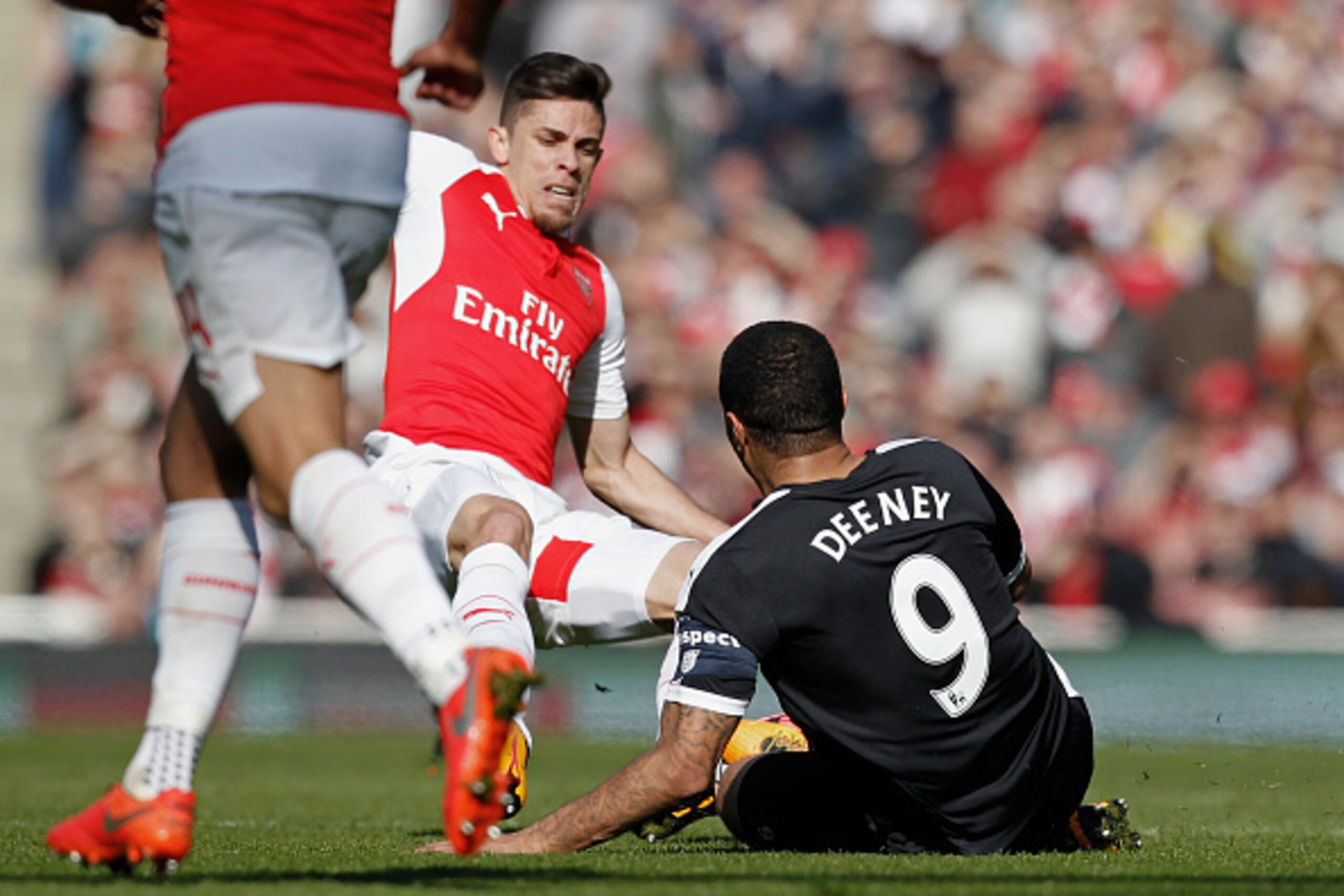Arsenal's Brazilian defender Gabriel (L) jumps in to make a tackle on Watford's English striker Troy Deeney (R) during the FA Cup quarter final football match between Arsenal and Watford at the Emirates Stadium in London on March 13, 2016.  / AFP / Ian Ki