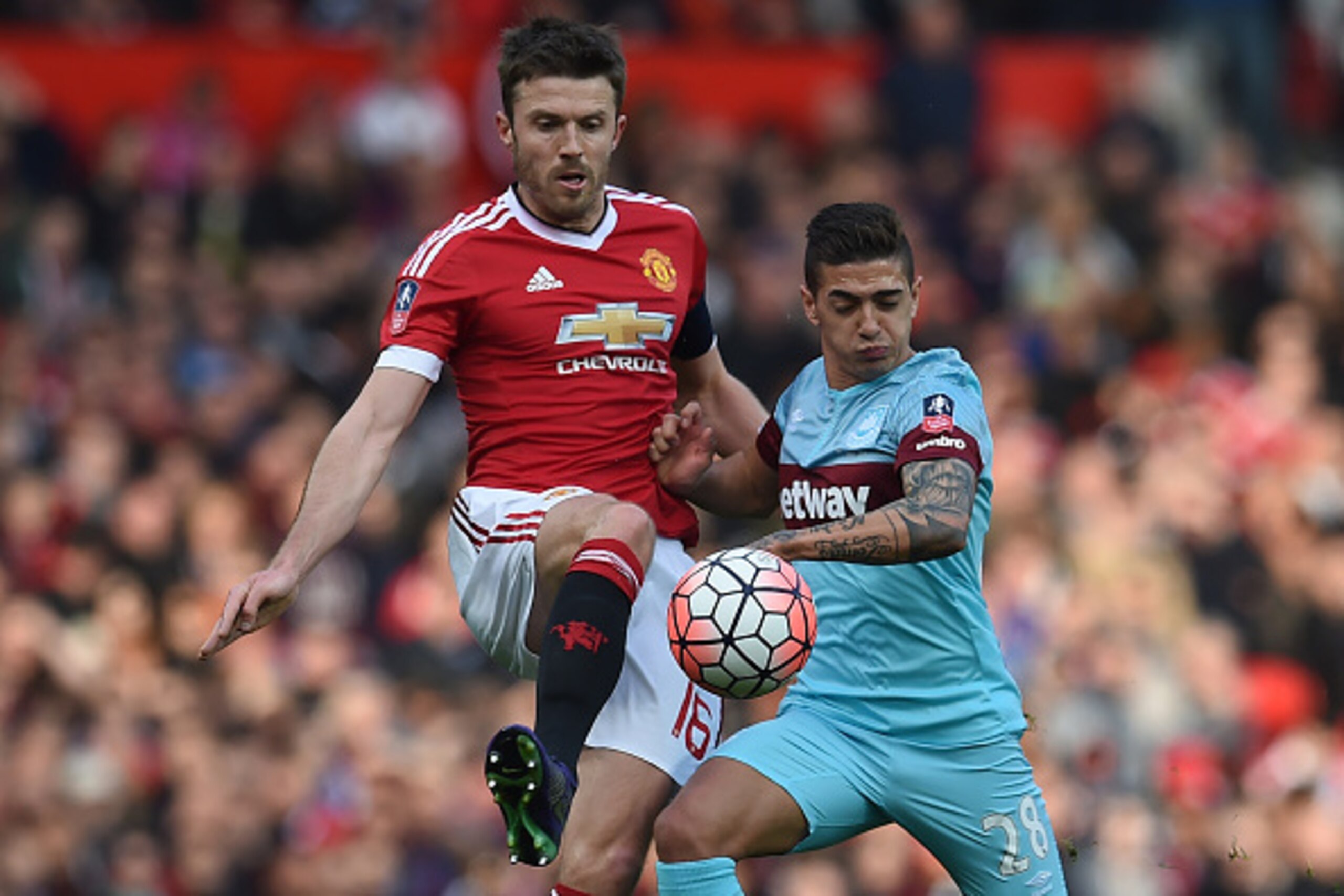 West Ham United's Argentinian midfielder Manuel Lanzini (R) vies with Manchester United's English midfielder Michael Carrick during the English FA Cup quarter final football match between Manchester United and West Ham United at Old Trafford in Manchester