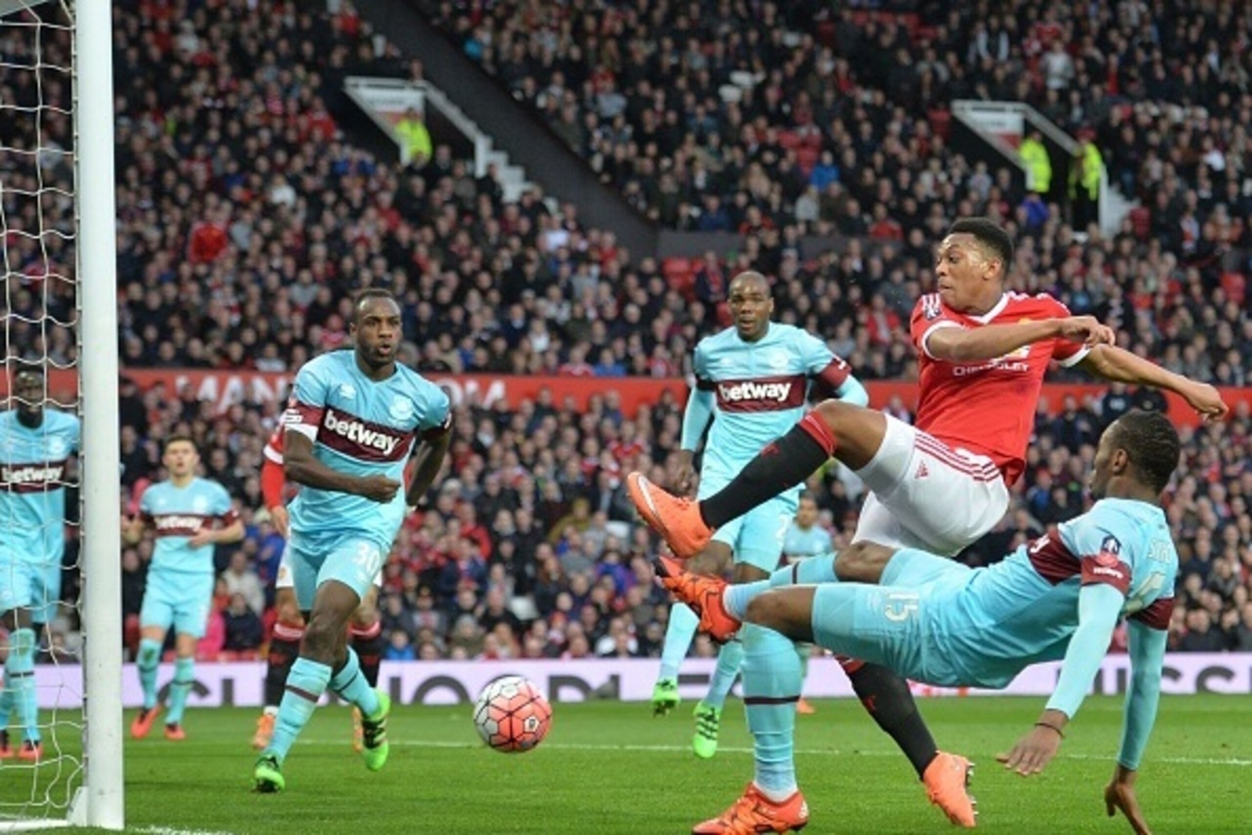 Manchester United's French striker Anthony Martial (2nd R) gets in front of West Ham United's Senegalese striker Diafra Sakho (R) to score their first goal during the English FA Cup quarter final football match between Manchester United and West Ham Unite