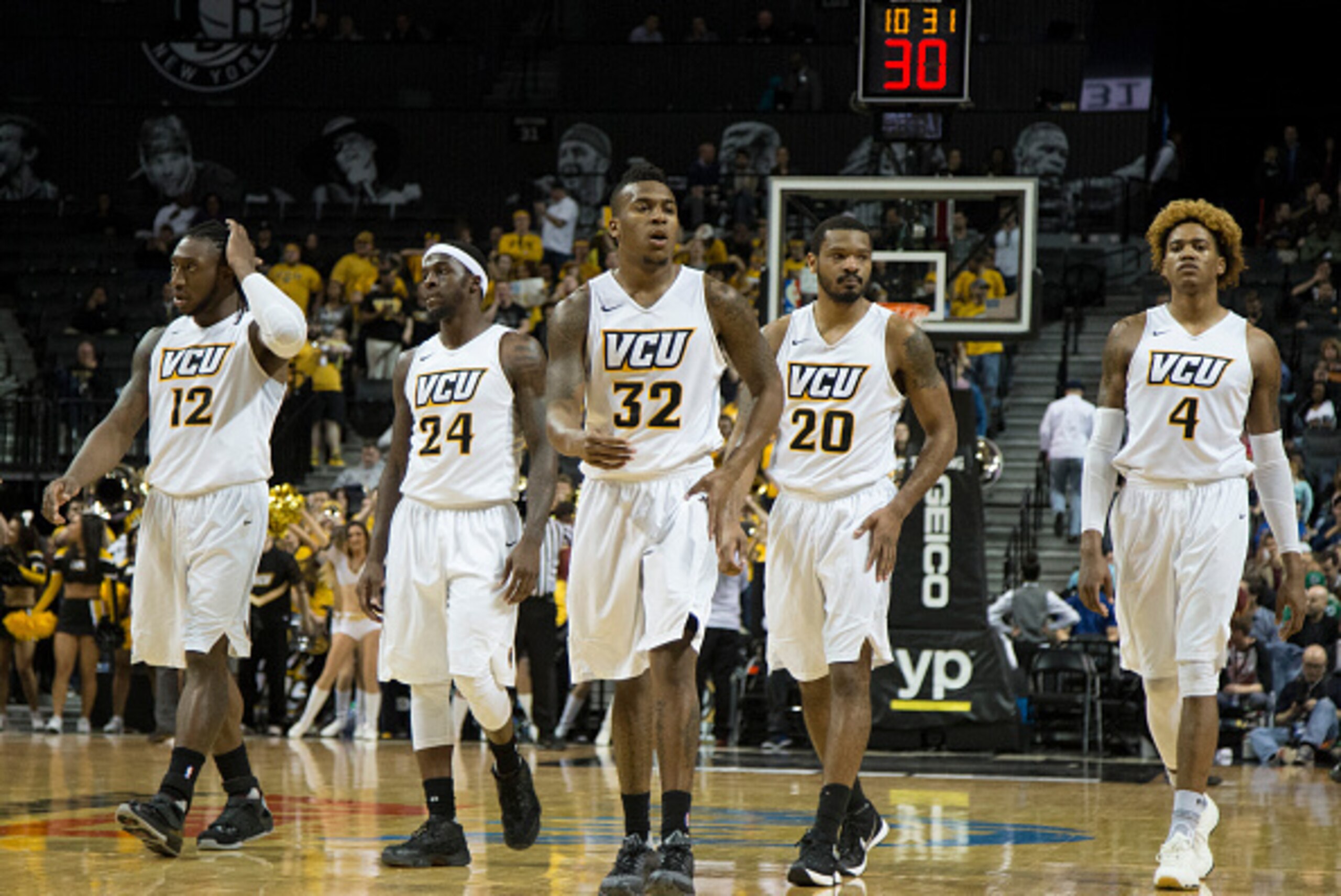NEW YORK, NY - MARCH 11: Mo Alie-Cox #12, Korey Billbury #24, Melvin Johnson #32, Jordan Burgess #20, and Justin Tillman #4 of the Virginia Commonwealth Rams walk on the court after a timeout in the game against the Massachusetts Minutemen in the quarterf