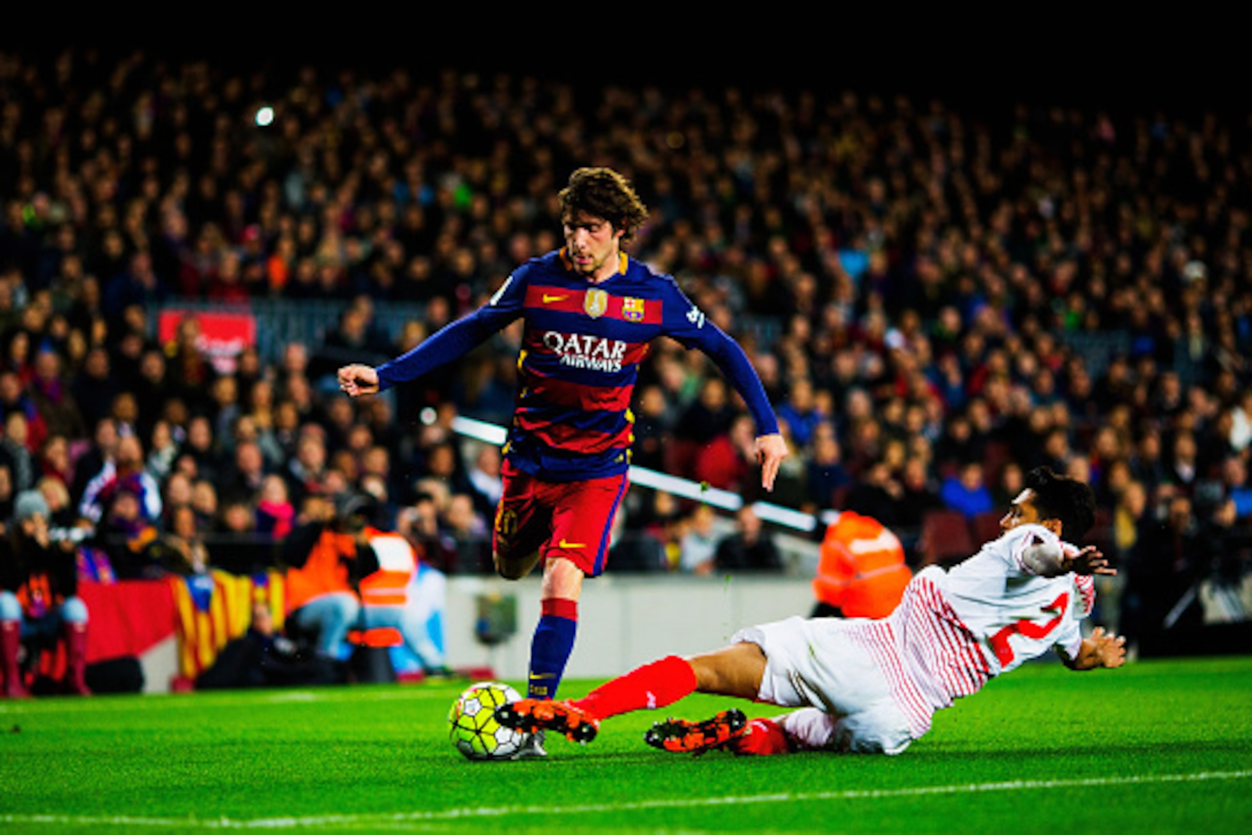 BARCELONA, SPAIN - FEBRUARY 28:  Sergi Roberto of Barcelona attacks as Benoit Tremoulinas of Sevilla slides in  during the La Liga match between FC Barcelona and Sevilla FC at Camp Nou on February 28, 2016 in Barcelona, Spain.  (Photo by Vladimir Rys Phot