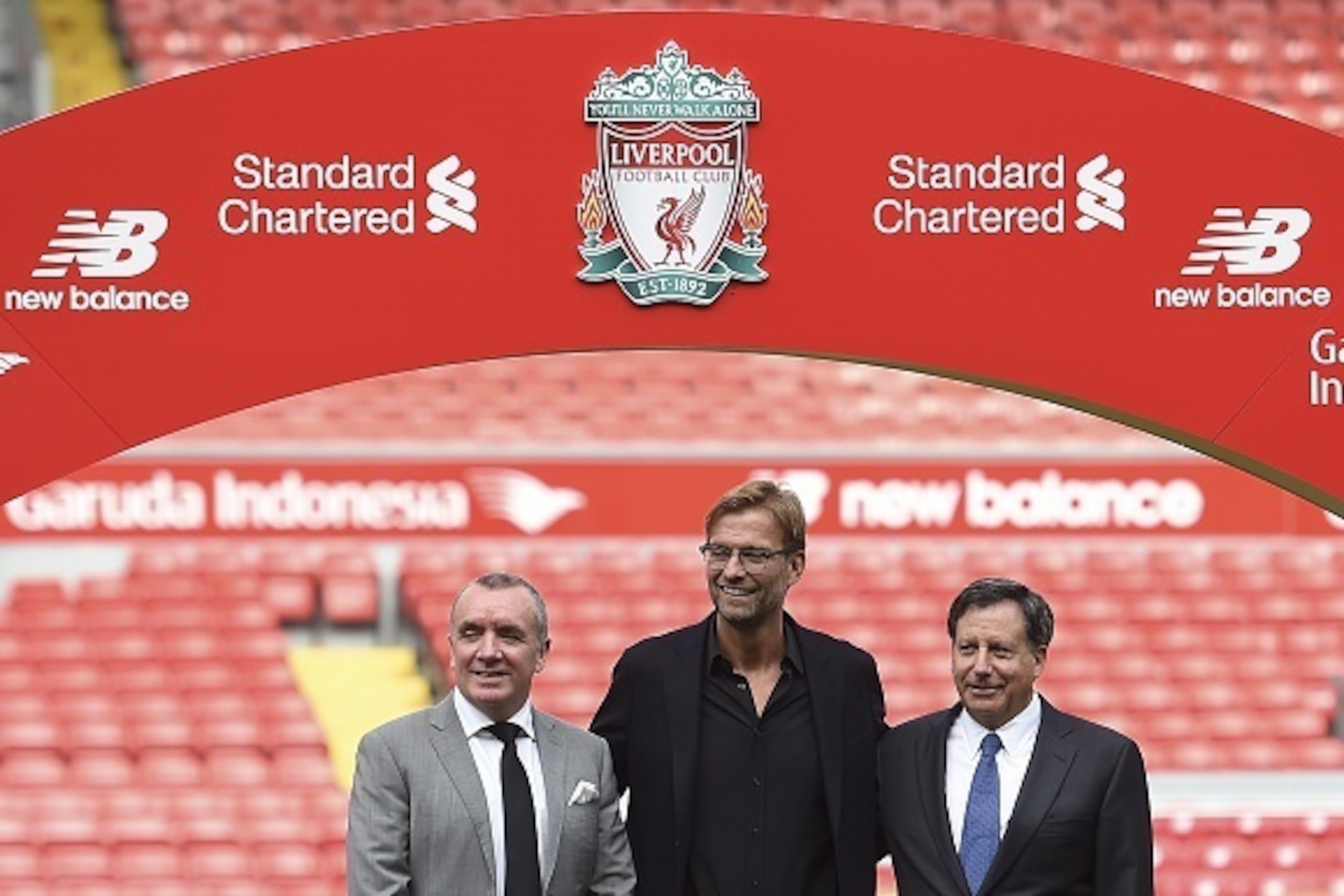 Liverpool's new German manager Jurgen Klopp (C) poses on the pitch next to Liverpool's chairman Tom Werner (R) and managing director Ian Ayre (L) after a press conference to announce his new appointment at Anfield in Liverpool, northwest England, on Octob
