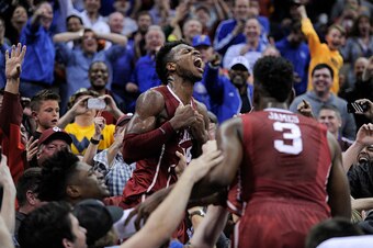 KANSAS CITY, MO - MARCH 11: Buddy Hield #24 of the Oklahoma Sooners celebrates with fans after he thought he made the game-winning basket against the West Virginia Mountaineers during the semifinals of the Big 12 Basketball Tournament at Sprint Center on 