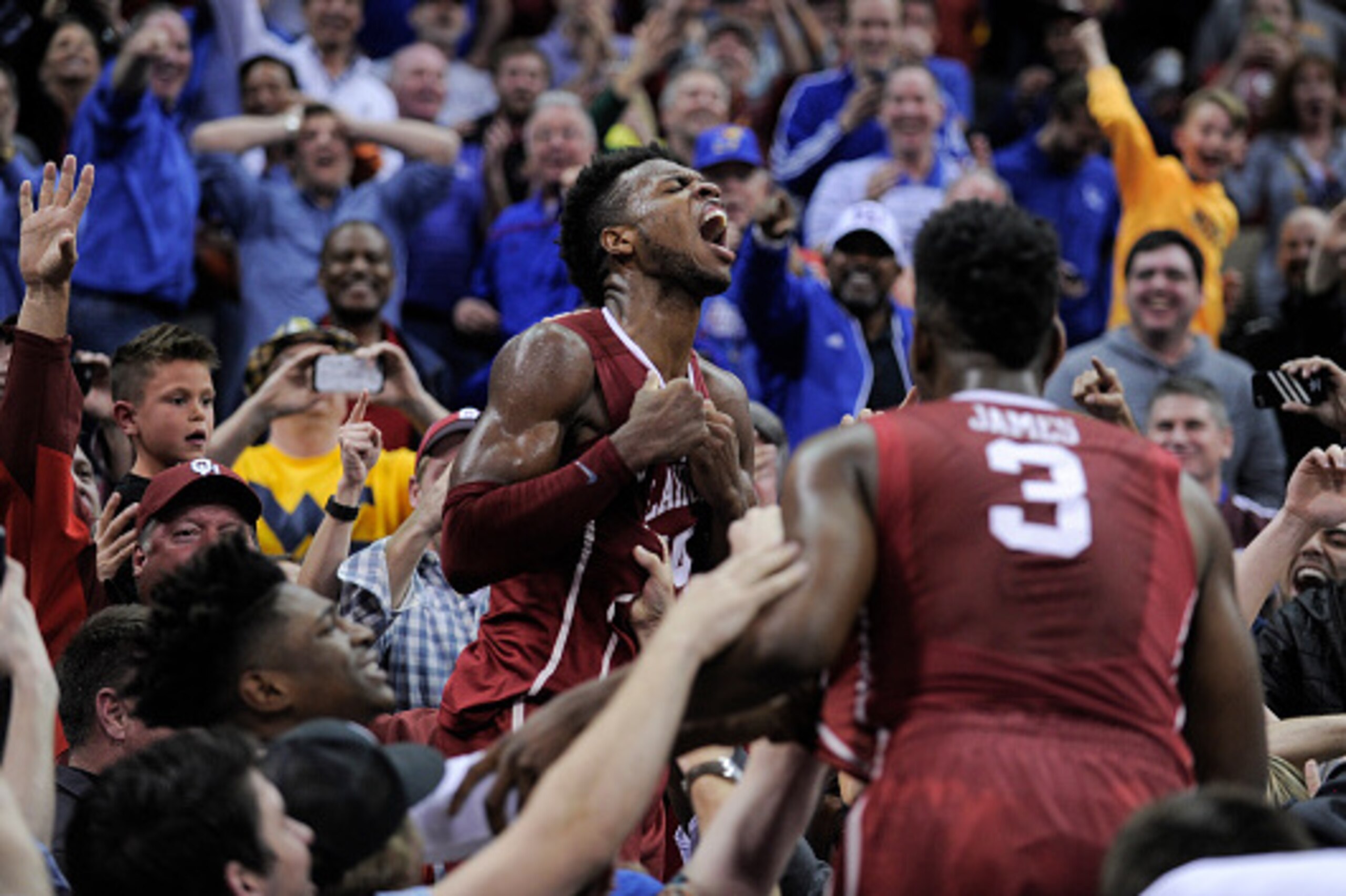KANSAS CITY, MO - MARCH 11: Buddy Hield #24 of the Oklahoma Sooners celebrates with fans after he thought he made the game-winning basket against the West Virginia Mountaineers during the semifinals of the Big 12 Basketball Tournament at Sprint Center on 