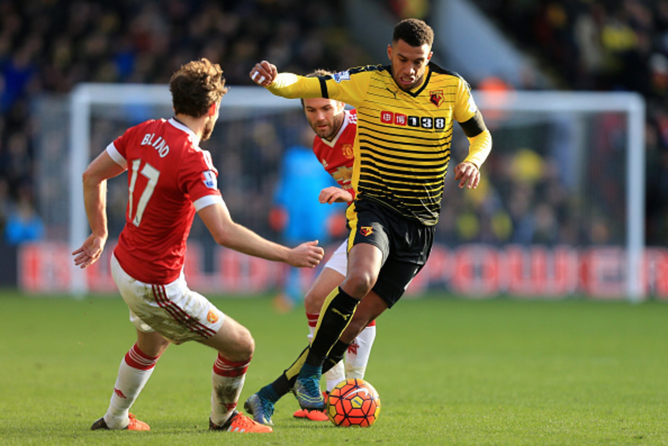 WATFORD, ENGLAND - NOVEMBER 21:  Etienne Capoue (R) of Watford competes for the ball with Daley Blind (L) and Juan Mata (C) of Manchester United during the Barclays Premier League match between Watford and Manchester United at Vicarage Road on November 21
