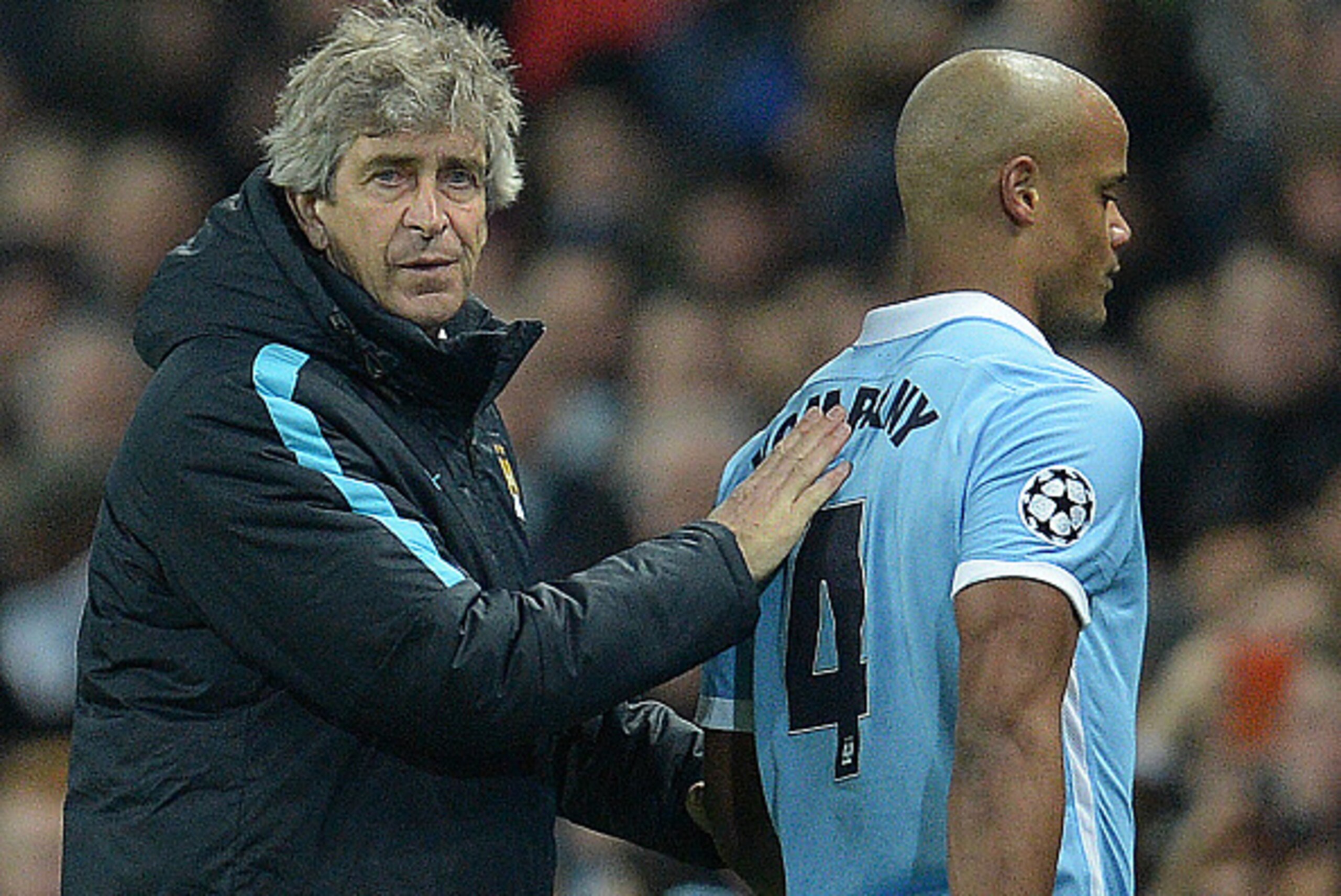 Manchester City's Chilean manager Manuel Pellegrini (L) consoles Manchester City's Belgian defender Vincent Kompany as he leaves the pitch injured during a UEFA Champions League last 16, second leg football match between Manchester City and Dynamo Kiev at