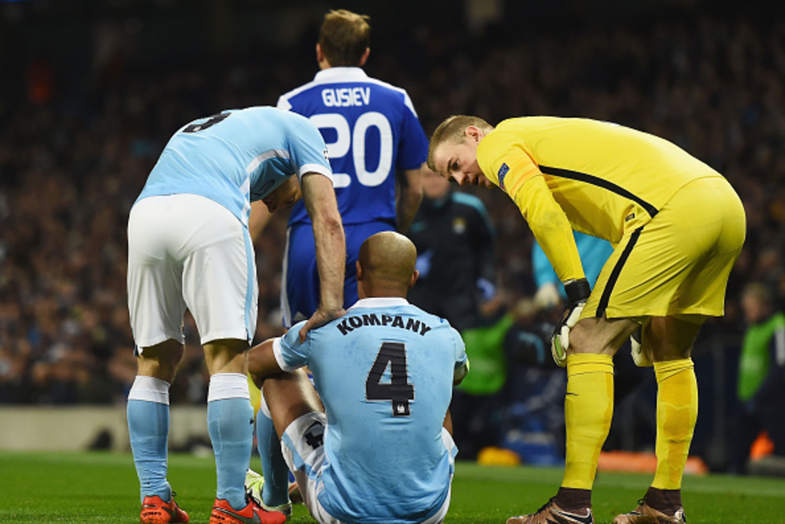MANCHESTER, ENGLAND - MARCH 15:  An injured Vincent Kompany of Manchester City (4) in discussion with team mates Pablo Zabaleta (L) and Joe Hart (R)  during the UEFA Champions League round of 16 second leg match between Manchester City FC and FC Dynamo Ky