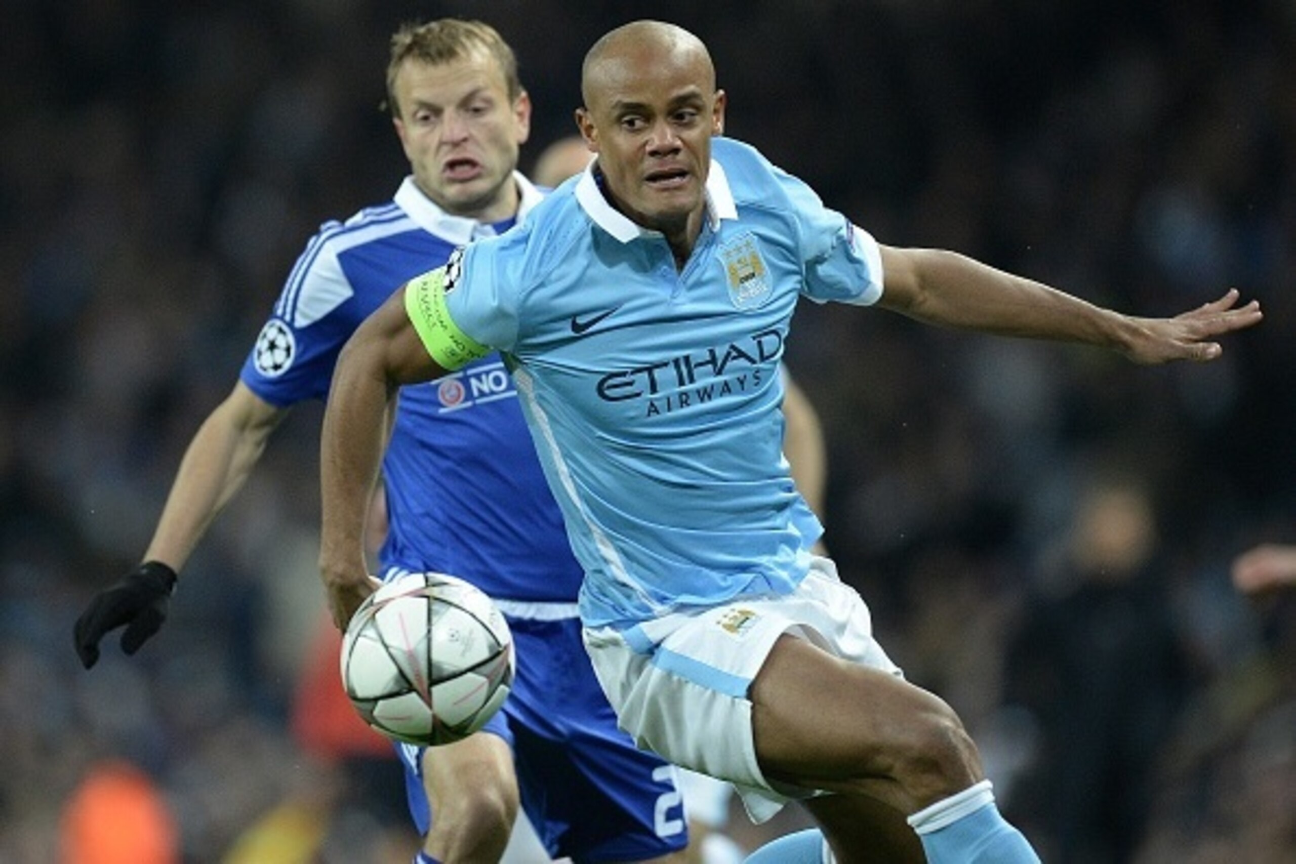 Manchester City's Belgian defender Vincent Kompany (R) vies with Dynamo Kiev's Russian midfielder Oleg Gusev during a UEFA Champions League last 16, second leg football match between Manchester City and Dynamo Kiev at the Etihad Stadium in Manchester, nor