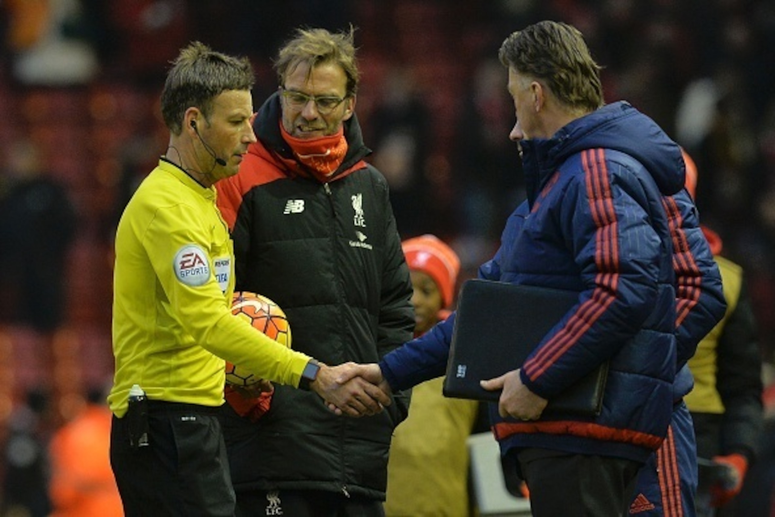 Manchester United's Welsh assistant manager Ryan Giggs (R obscured) shakes hands with referee Mark Clattenburg (L) as Manchester United's Dutch manager Louis van Gaal (R) and Liverpool's German manager Jurgen Klopp (2L) look on after the English Premier L