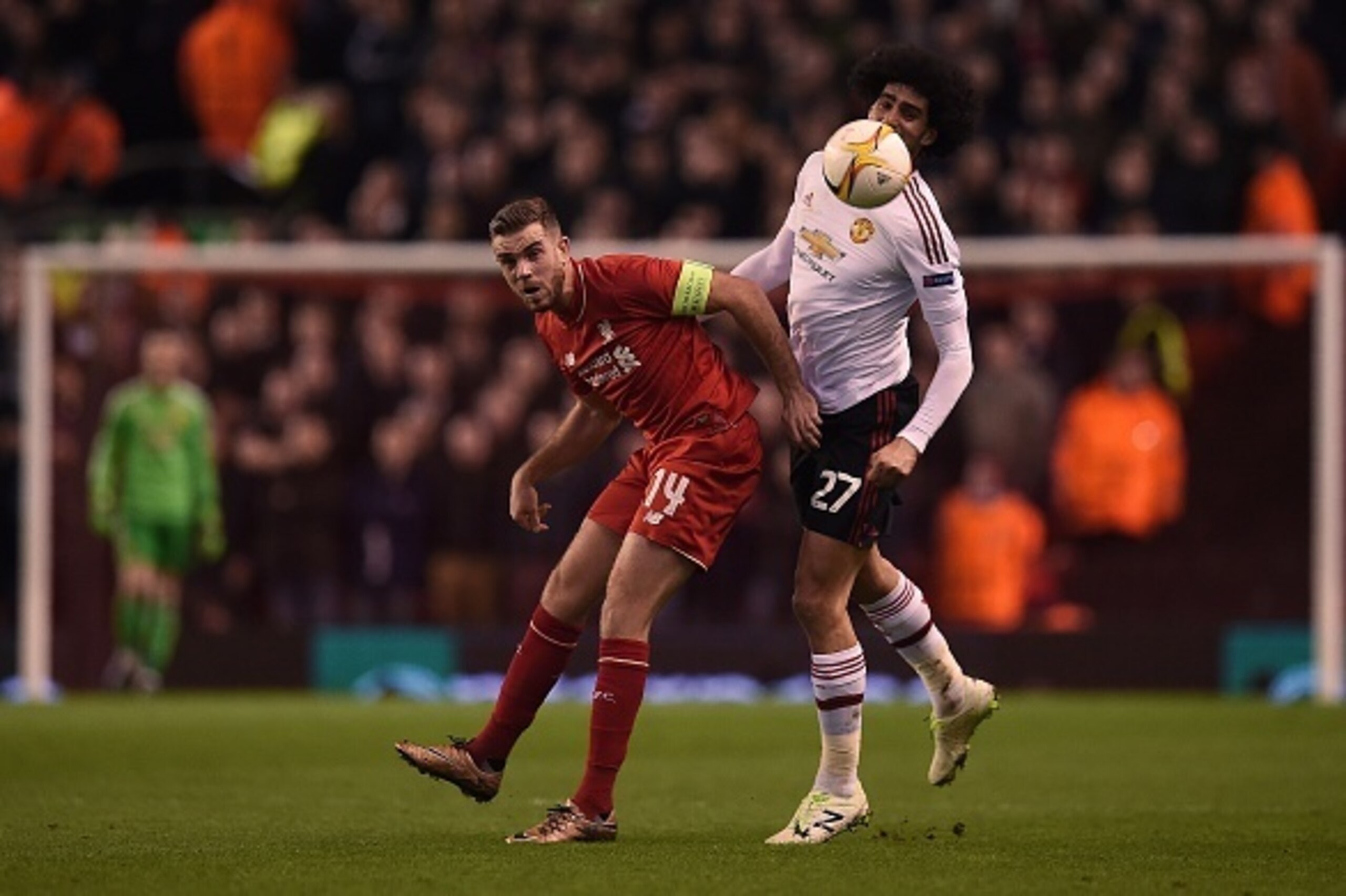 Liverpool's English midfielder Jordan Henderson (L) vies iwth Manchester United's Belgian midfielder Marouane Fellaini during the UEFA Europa League round of 16, first leg football match between Liverpool and Manchester United at Anfield in Liverpool, nor