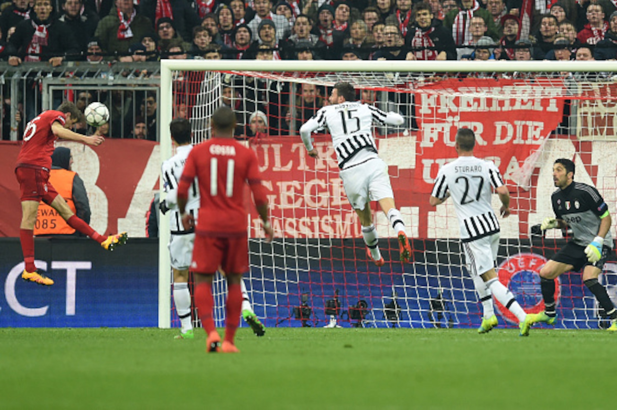 Bayern Munich's midfielder Thomas Mueller (L) makes a head to score the equalise goal in the first minute of added time during the UEFA Champions League, Round of 16, second leg football match FC Bayern Munich v Juventus in Munich, southern Germany on Mar
