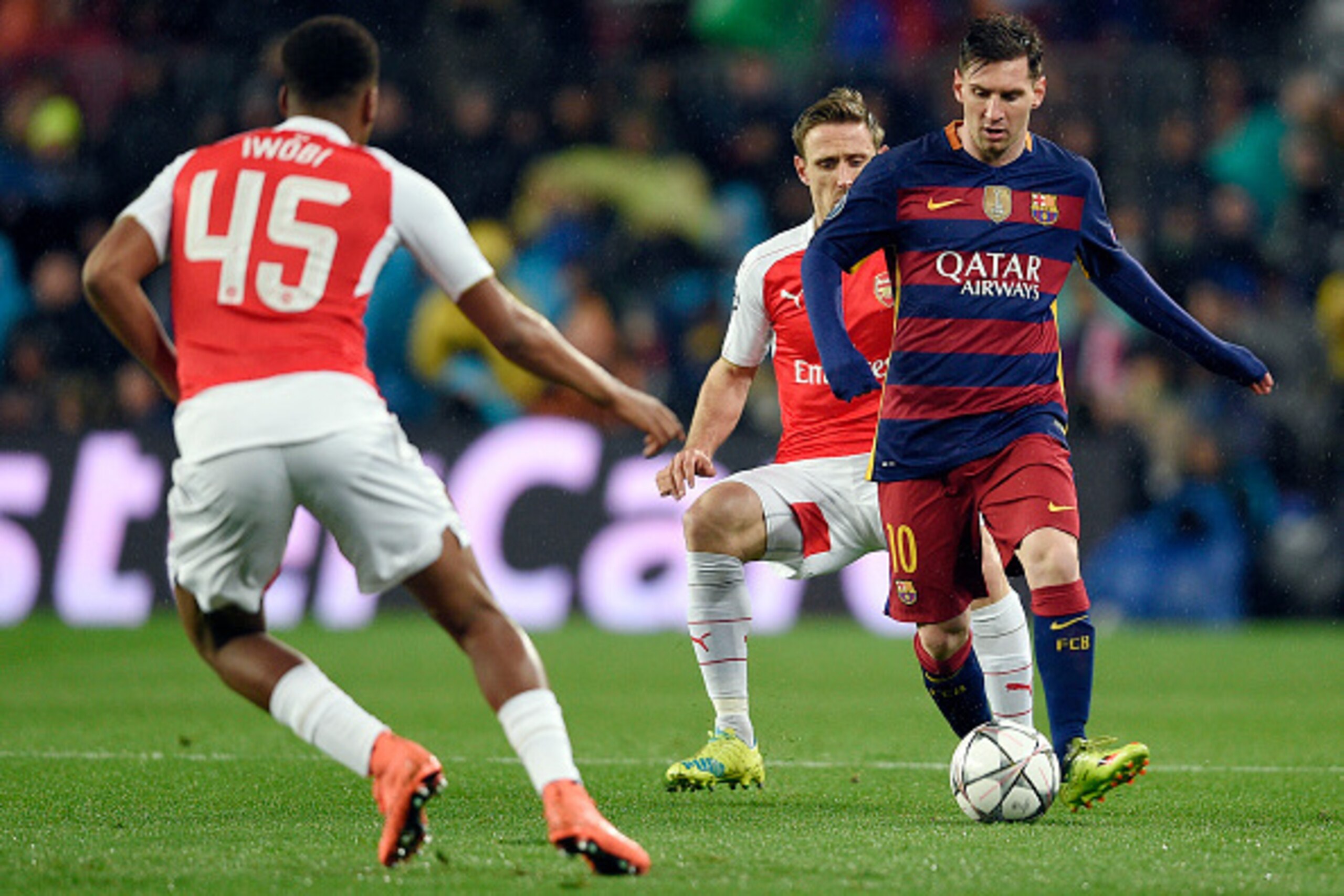 Barcelona's Argentinian forward Lionel Messi (R) vies with Arsenal's Nigerian forward Alex Iwobi during the UEFA Champions League Round of 16 second leg football match FC Barcelona vs Arsenal FC at the Camp Nou stadium in Barcelona on March 16, 2016.  / A