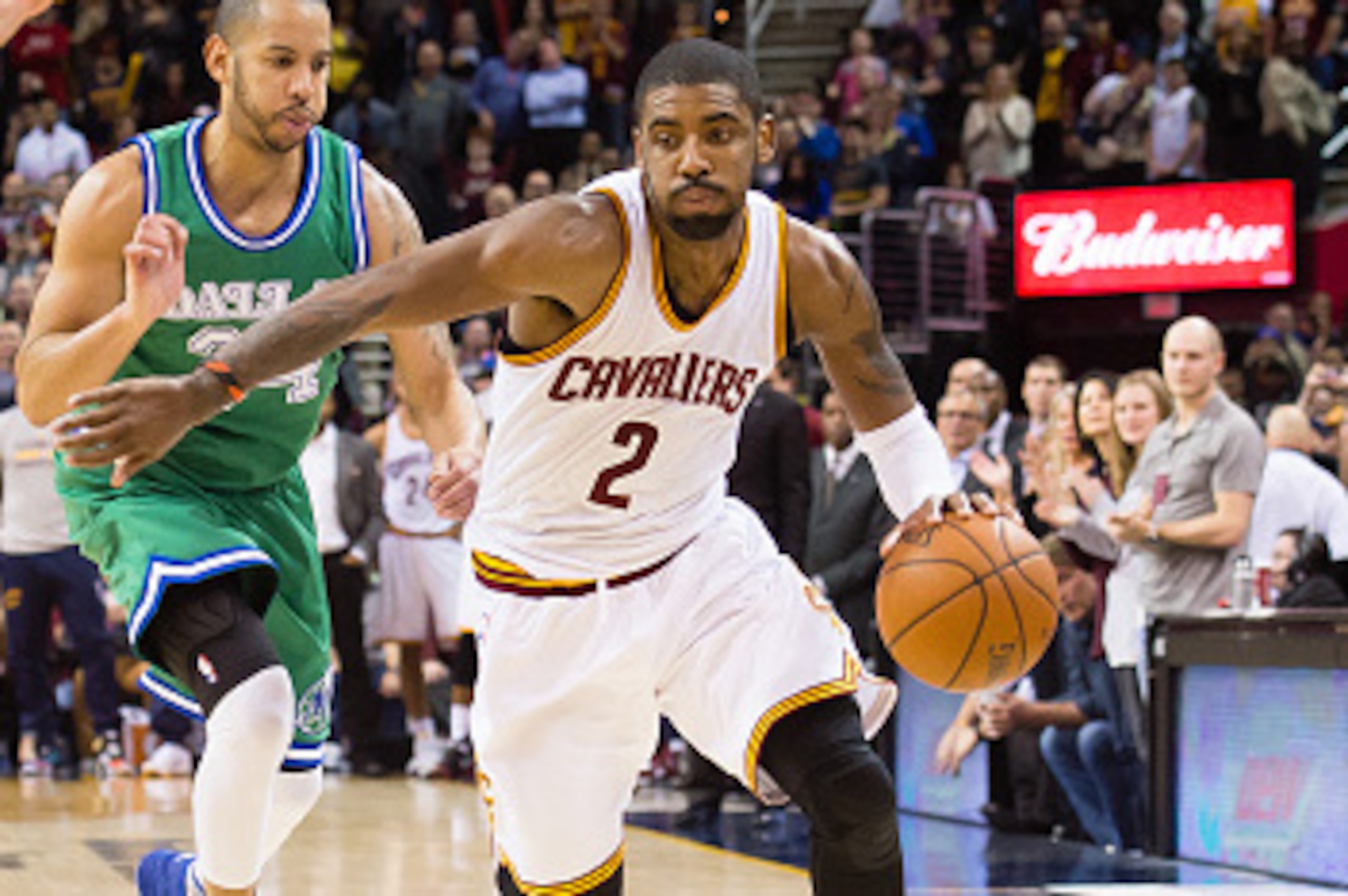 CLEVELAND, OH - MARCH 16: Kyrie Irving #2 of the Cleveland Cavaliers drives around Zaza Pachulia #27 and Devin Harris #34 of the Dallas Mavericks during the second half at Quicken Loans Arena on March 16, 2016 in Cleveland, Ohio. The Cavaliers defeated th