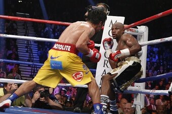 Floyd Mayweather Jr. exchange punches with Manny Pacquiao during their welterweight unification championship bout, May 2, 2015 at MGM Grand Garden Arena in Las Vegas, Nevada.  Mayweather defeated Pacquiao by unanimous decision.  AFP PHOTO / JOHN GURZINKSI