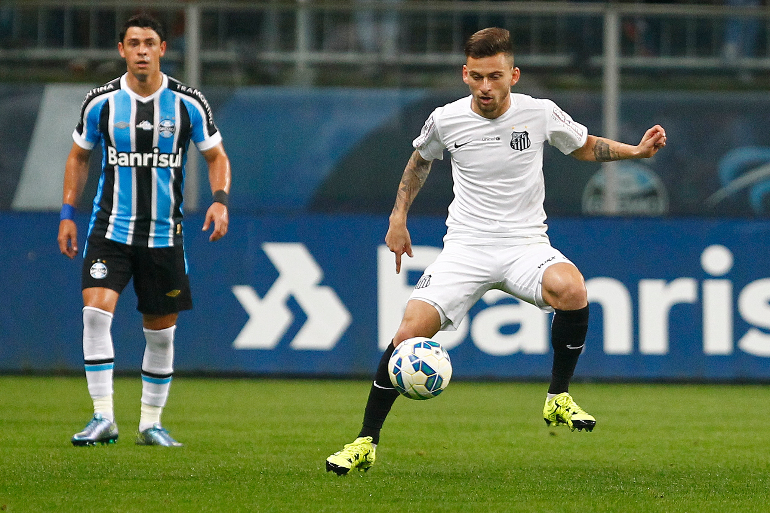 PORTO ALEGRE, BRAZIL - OCTOBER 15: Giuliano of Gremio battles for the ball against Lucas Lima of Santos during the match Gremio v Santos as part of Brasileirao Series A 2015, at Arena do Gremio on October 15, 2015 in Porto Alegre, Brazil. (Photo by Lucas