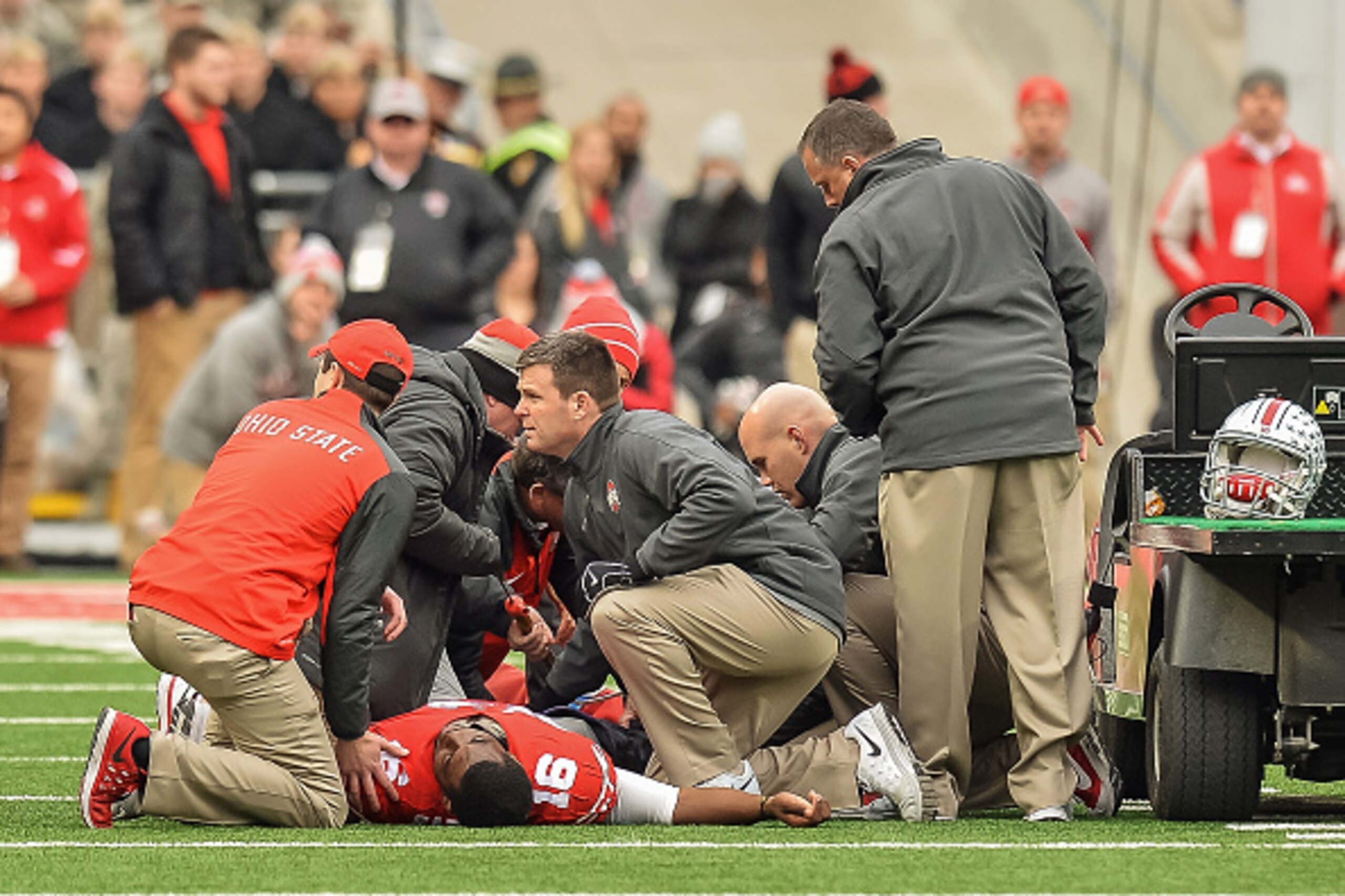 COLUMBUS, OH - NOVEMBER 29:  Doctors and trainers attend to quarterback J.T. Barrett #16 of the Ohio State Buckeyes after Barrett injured his ankle against the Michigan Wolverines at Ohio Stadium on November 29, 2014 in Columbus, Ohio. Ohio State defeated