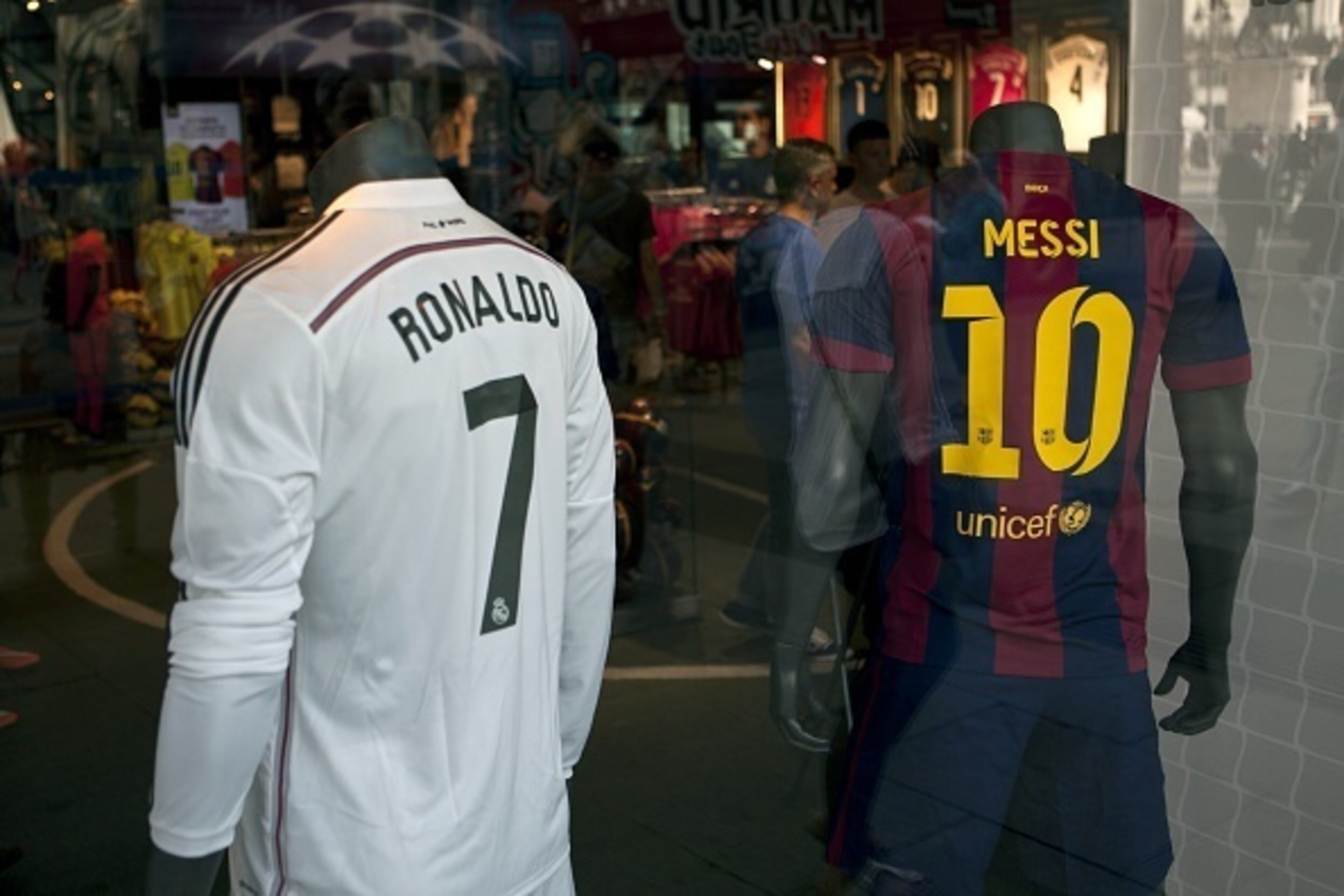 Two store mannequins sport the jerseys of Real Madrid's Portuguese forward Ronaldo Cristiano (L) and Barcelona's Argentinian forward Lionel Messi in a shop window at Puerta del Sol, in the centre of Madrid on October 23, 2014. Real Madrid meet Barcelona f Two store mannequins sport the jerseys of Real Madrid's Portuguese forward Ronaldo Cristiano (L) and Barcelona's Argentinian forward Lionel Messi in a shop window at Puerta del Sol, in the centre of Madrid on October 23, 2014. Real Madrid meet Barcelona f