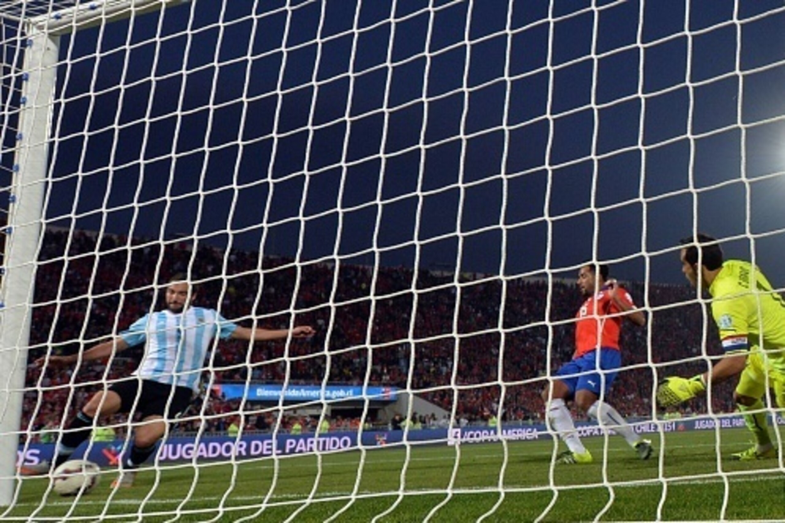 Argentina's forward Gonzalo Higuain (L) kicks the ball next to Chile's goalkeeper Claudio Bravo (R) and midfielder Jean Beausejour during their 2015 Copa America football championship final, in Santiago, Chile, on July 4, 2015.   AFP PHOTO / NELSON ALMEID