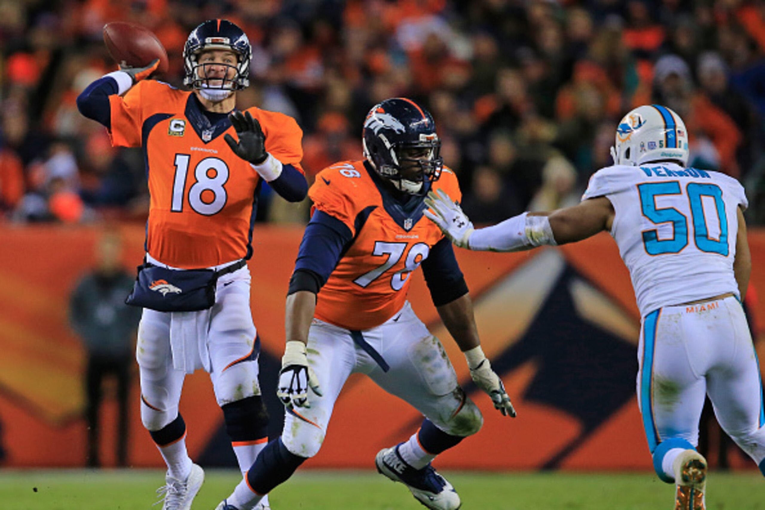 DENVER, CO - NOVEMBER 23:  Quarterback Peyton Manning #18 of the Denver Broncos delivers a pass as tackle Ryan Clady #78 of the Denver Broncos blocks against defensive end Olivier Vernon #50 of the Miami Dolphins at Sports Authority Field at Mile High on 