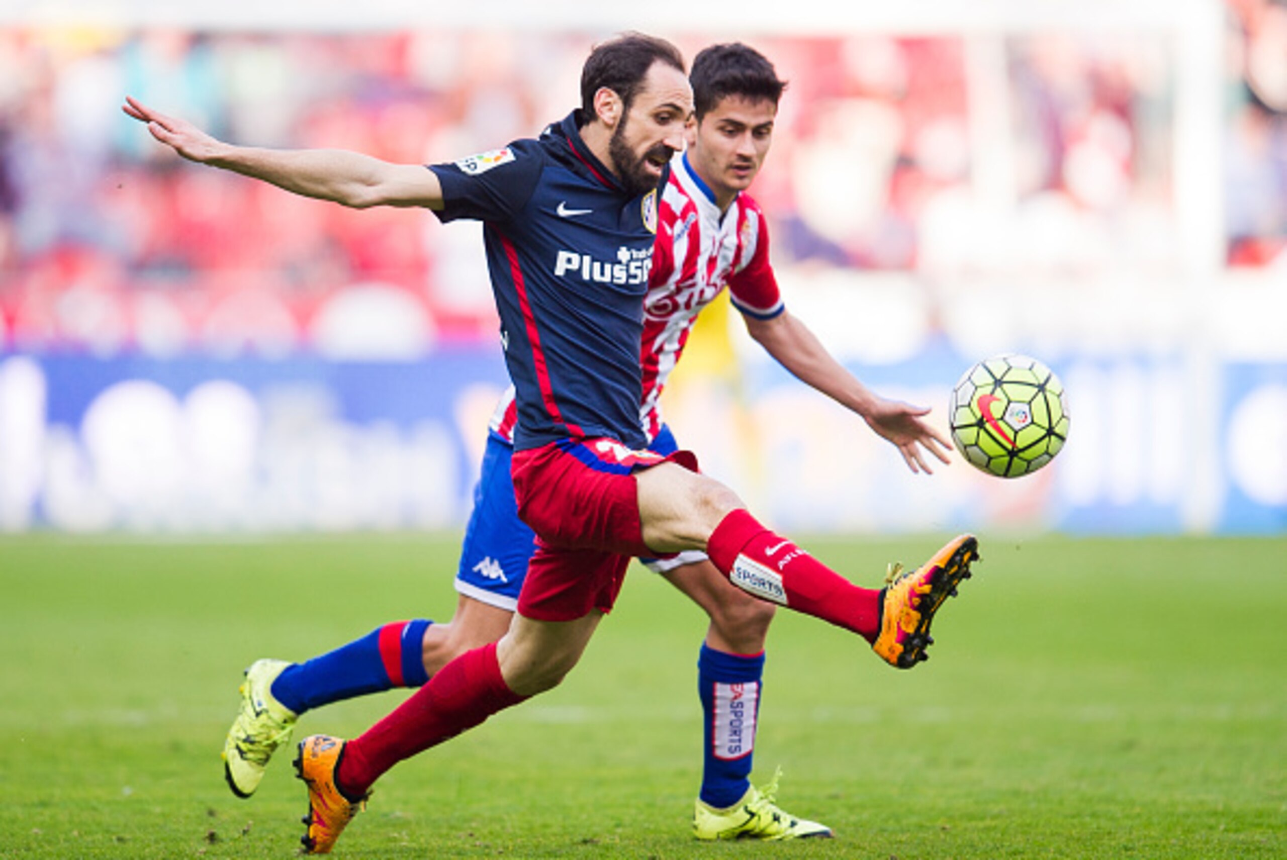 GIJON, SPAIN - MARCH 19:  Juanfran Torres of Club Atletico de Madrid duels for the ball with Nacho Cases of Real Sporting de Gijon during the La Liga match between Real Sporting de Gijon and Club Atletico de Madrid at Estadio El Molinon on March 19, 2016 
