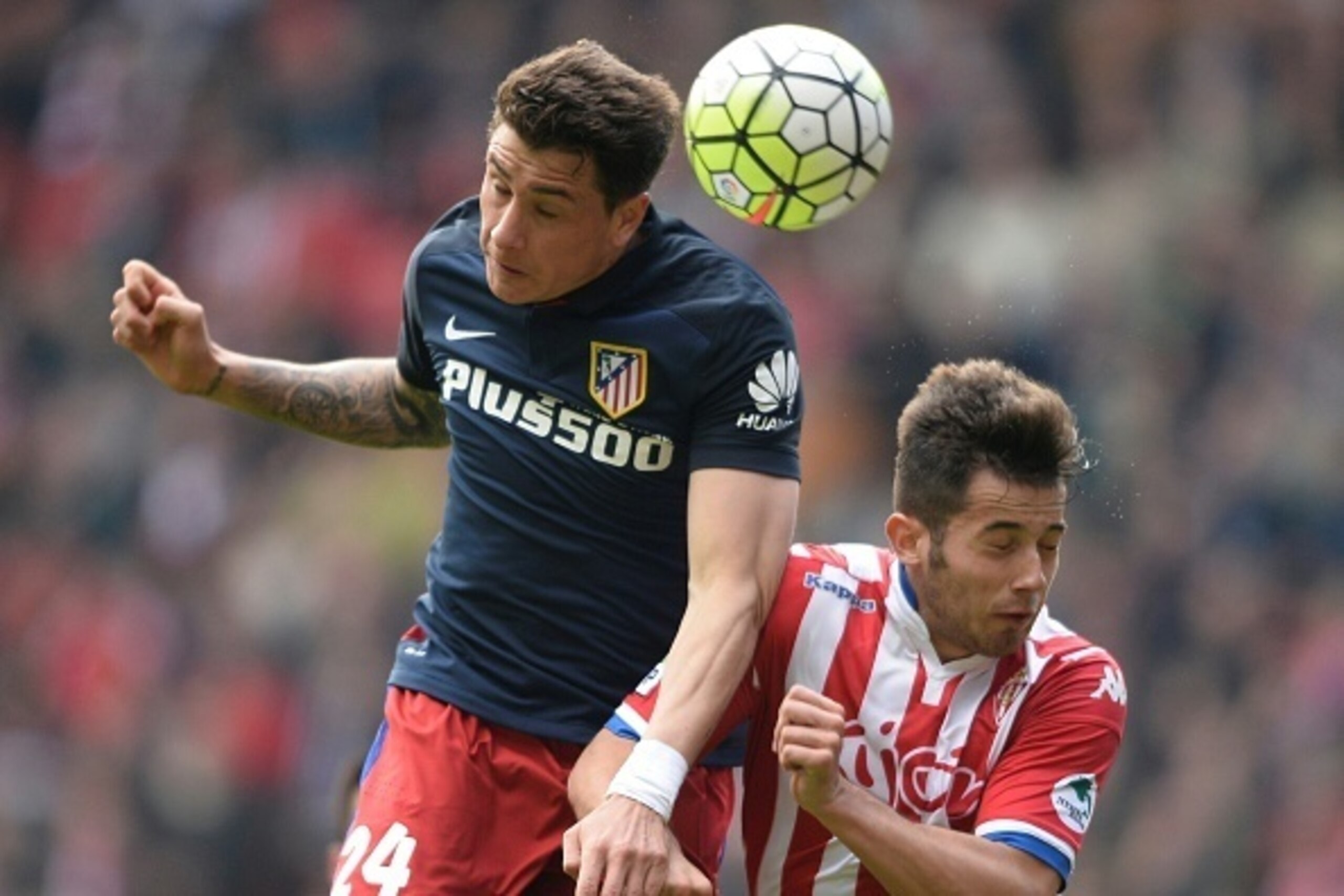 Atletico Madrid's Uruguayan defender Jose Maria Gimenez (L) heads the ball with Sporting Gijon's midfielder Jony during the Spanish league football match Real Sporting de Gijon vs Club Atletico de Madrid at El Molinon stadium in Gijon on March 19, 2016. /