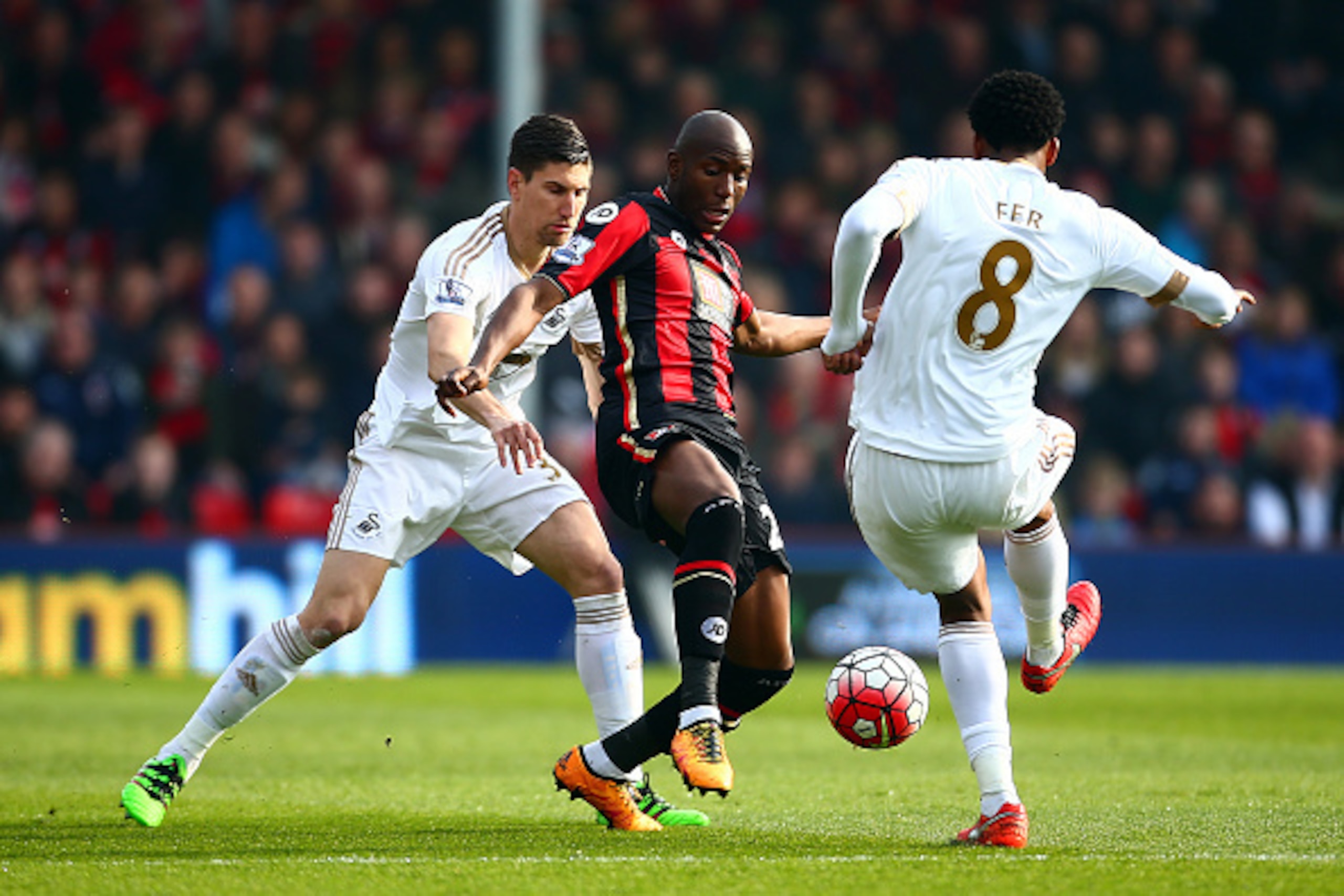 BOURNEMOUTH, ENGLAND - MARCH 12: Benik Afobe (C) of Bournemouth controls the ball under pressure of Federico Fernandez (L) and Leroy Fer (R) of Swansea City  during the Barclays Premier League match between A.F.C. Bournemouth and Swansea City at Vitality 