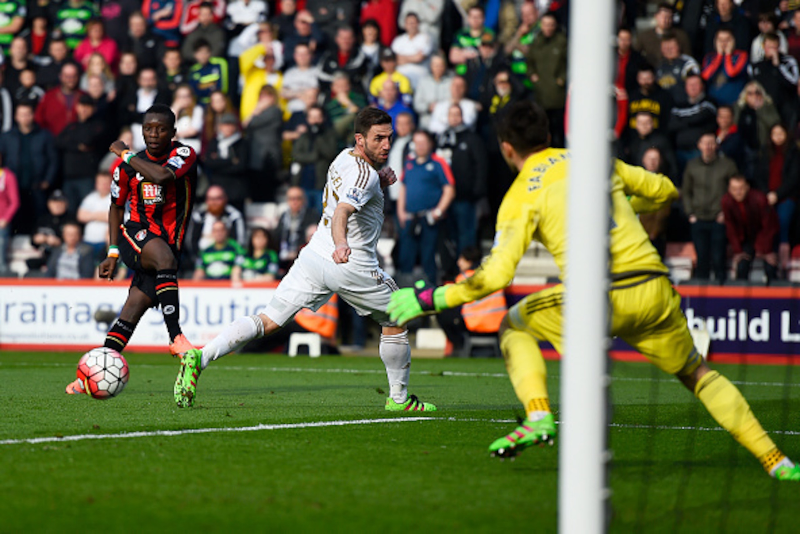 BOURNEMOUTH, ENGLAND - MARCH 12: Max Gradel (1st L) of Bournemouth scores his team's first goal past Lukasz Fabianski of Swansea City during the Barclays Premier League match between A.F.C. Bournemouth and Swansea City at Vitality Stadium on March 12, 201