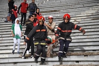 Moroccan emergency personnel carry an injured supporter following clashes between rival fans of Raja de Casablanca football club at the end of their match against Chabab Rif Al Hoceima on March 19, 2016, at the Mohammed V stadium in Casablanca. / AFP / ST