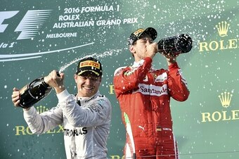 Mercedes AMG Petronas F1 Team's German driver Nico Rosberg (L) sprays champagne as he celebrates his win with third placed Ferrari's German driver Sebastian Vettel on the podium at the end of the Formula One Australian Grand Prix in Melbourne on March 20,