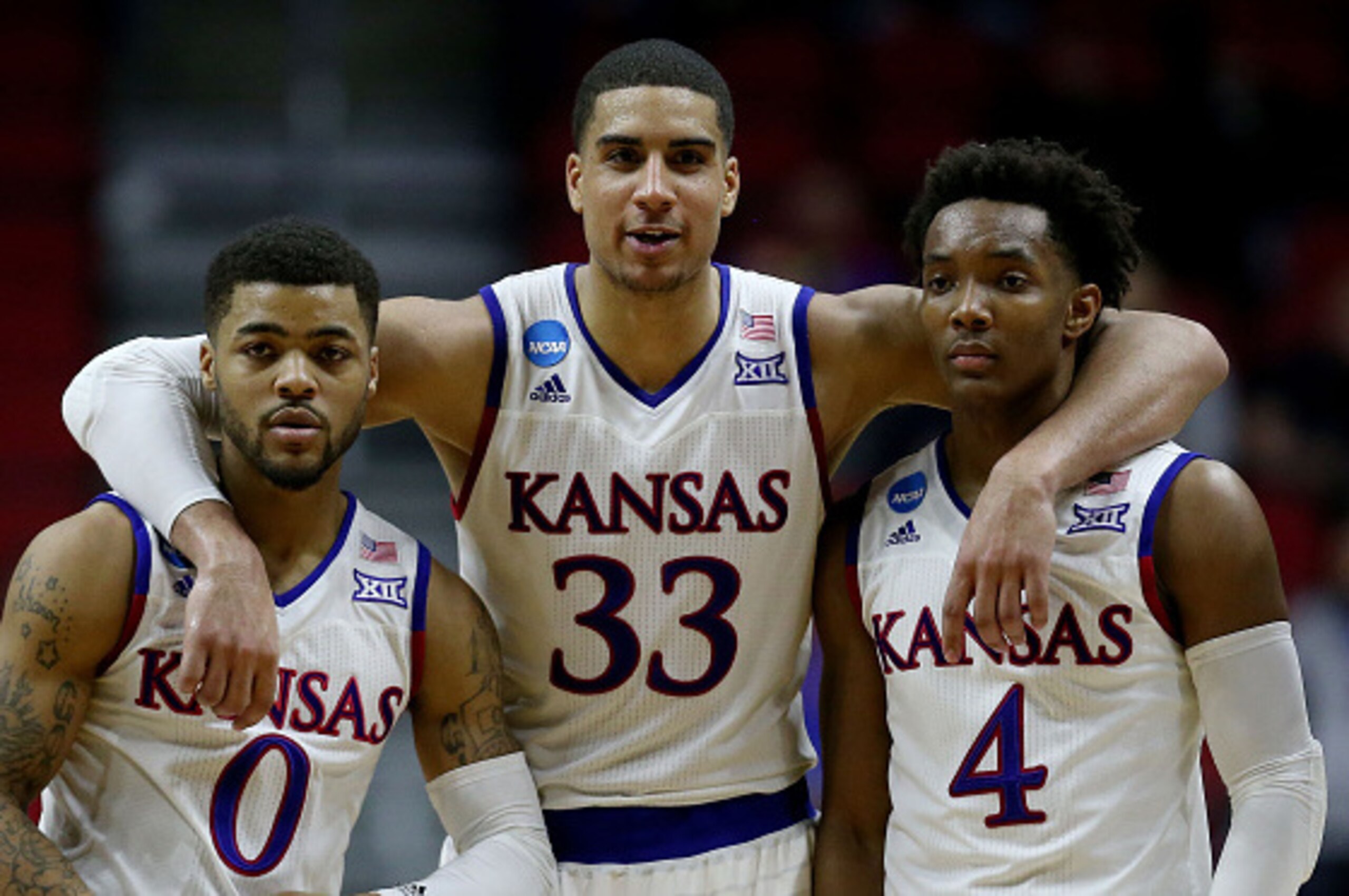 DES MOINES, IA - MARCH 19:  Frank Mason III #0 Landen Lucas #33 and Devonte' Graham #4 of the Kansas Jayhawks celebrate after defeating the Connecticut Huskies 73 to 61 during the second round of the 2016 NCAA Men's Basketball Tournament at Wells Fargo Ar