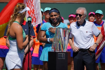 Victoria Azarenka shares kind remarks with Serena Williams during the 2016 BNP Paribas Open trophy ceremony as Raymond Moore looks on.